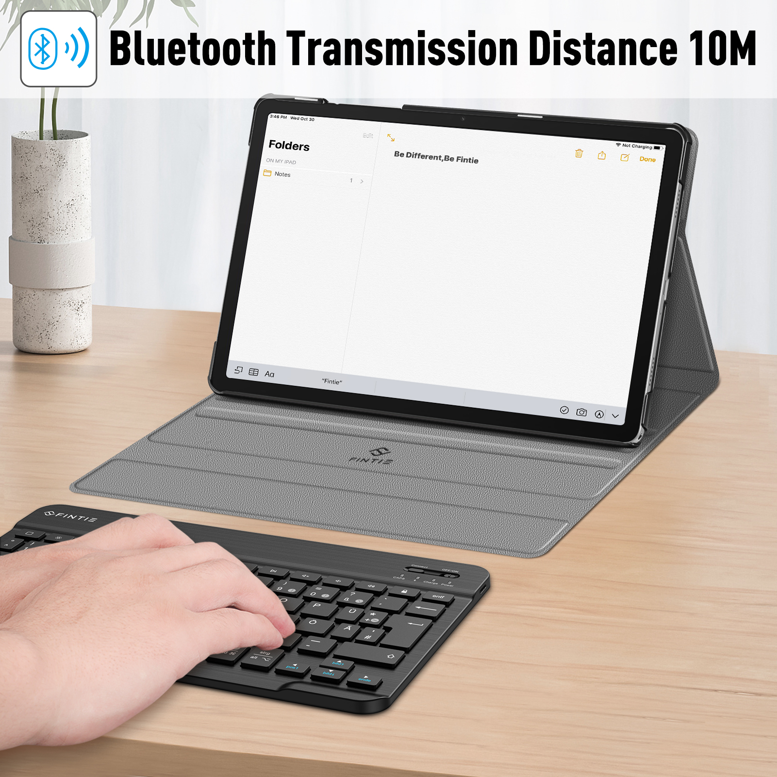 Tablet mit Tastatur, Notiz-App, Holzoberfläche, blauer Text.