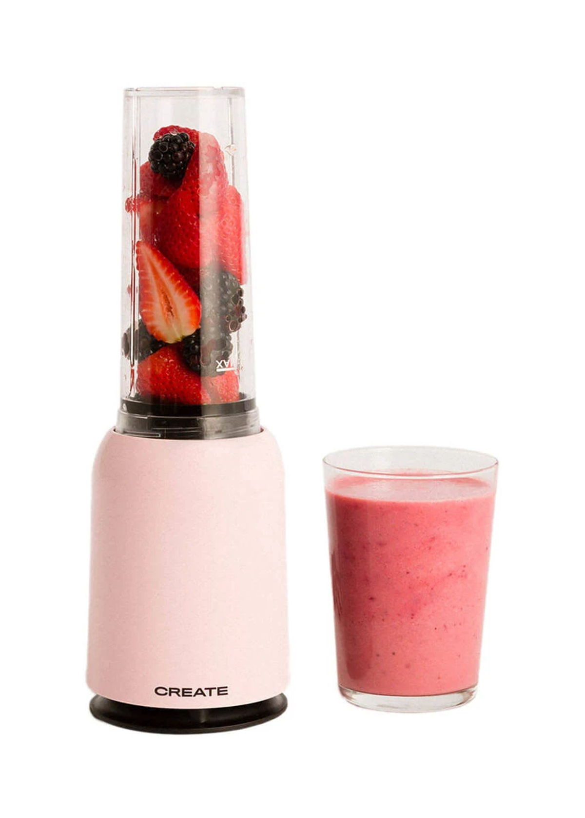 Licuadora rosa con fresas y moras, junto a un vaso de batido rosa.