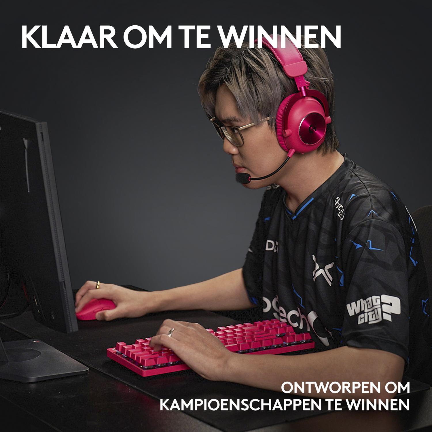 Mężczyzna z różowym zestawem słuchawkowym, klawiaturą i myszą, grający w grę. Słowa po holendersku.