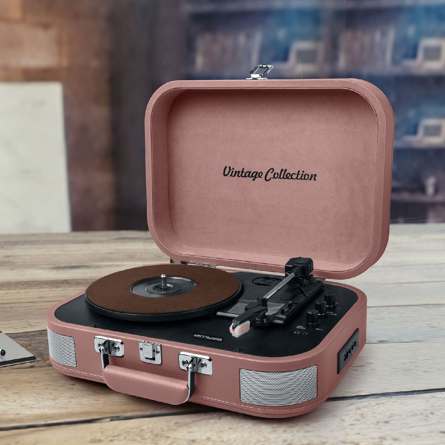 Un tocadiscos vintage rosa con tapa abierta sobre una mesa de madera.