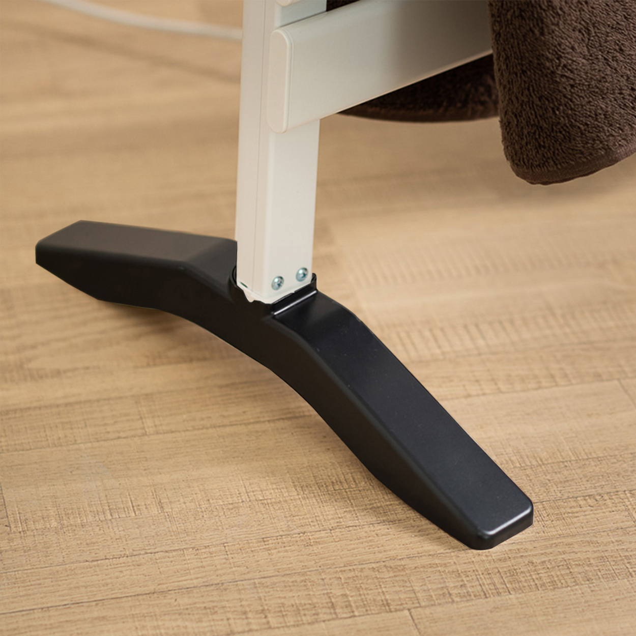 Primer plano de una pata de mesa en blanco y negro, con suelo de madera al fondo.