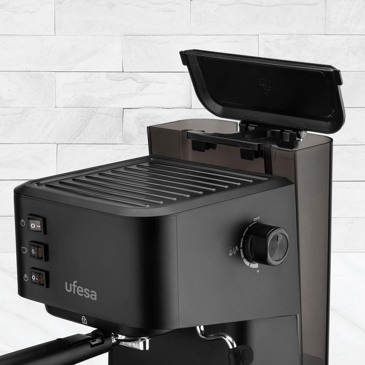 Máquina de espresso Ufesa negra con tapa abierta. El fondo es una pared de ladrillos blancos.