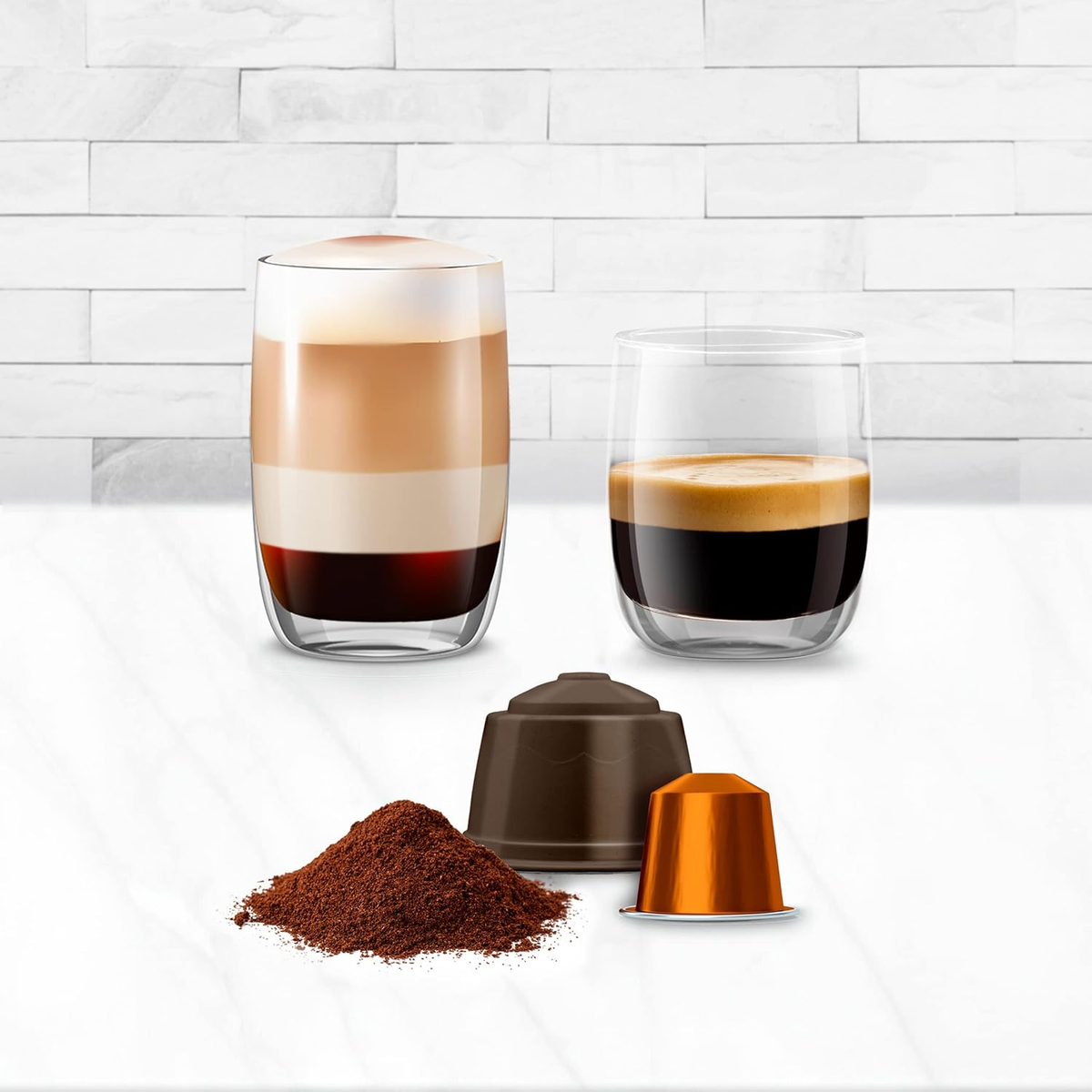 Due bicchieri di caffè, capsule e caffè macinato su un tavolo bianco.