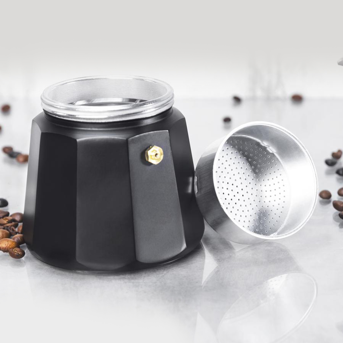 Czarny i srebrny ekspres do kawy z ziarnami kawy wokół niego.