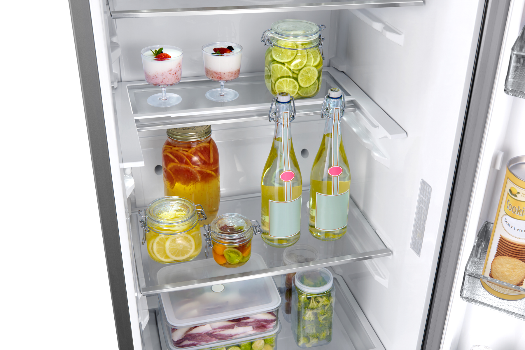 Interior de refrigerador con frascos de comida, bebidas e ingredientes. Estantes de vidrio visibles.