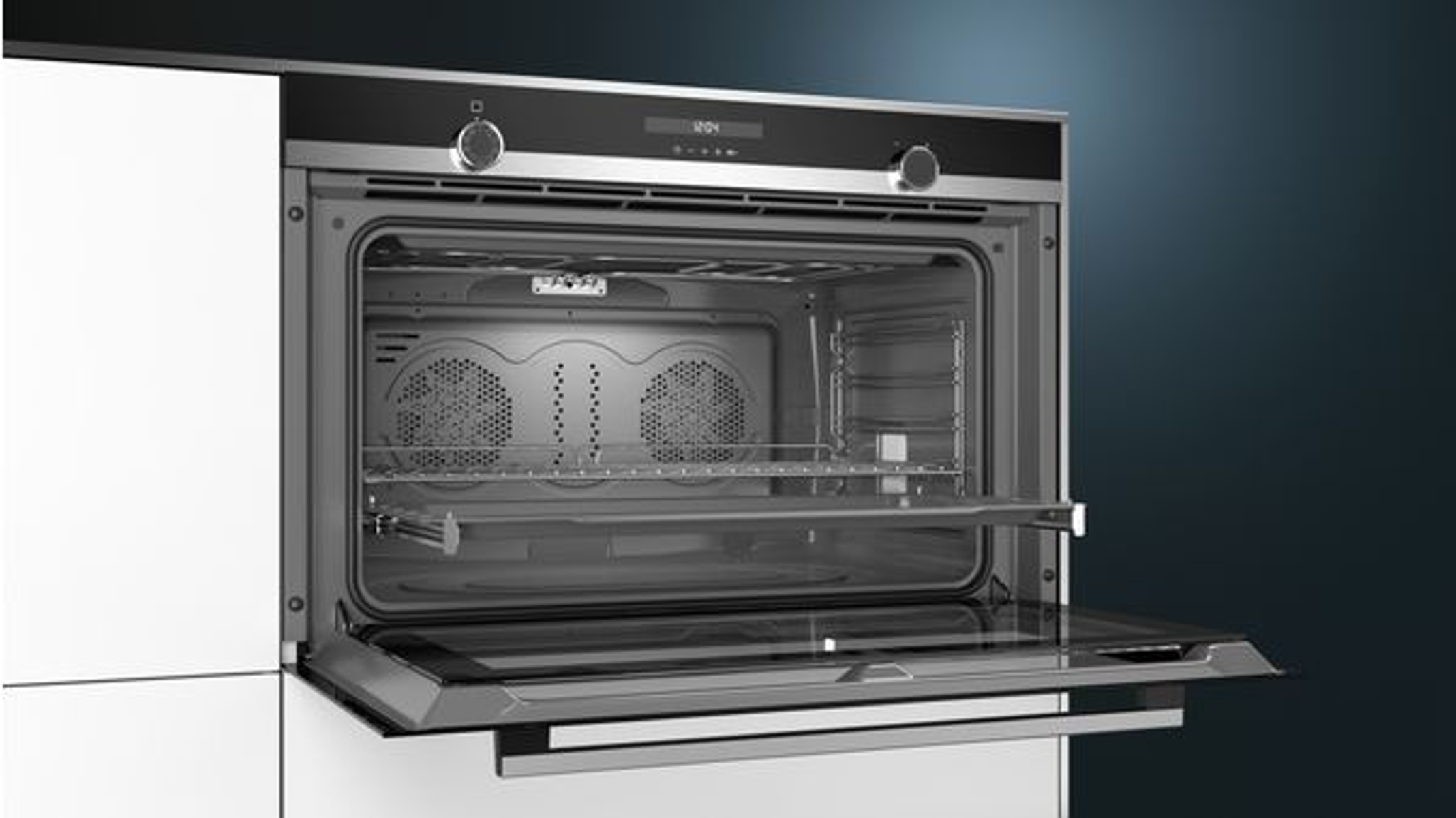 An open oven with two fans in the back and a glass door.