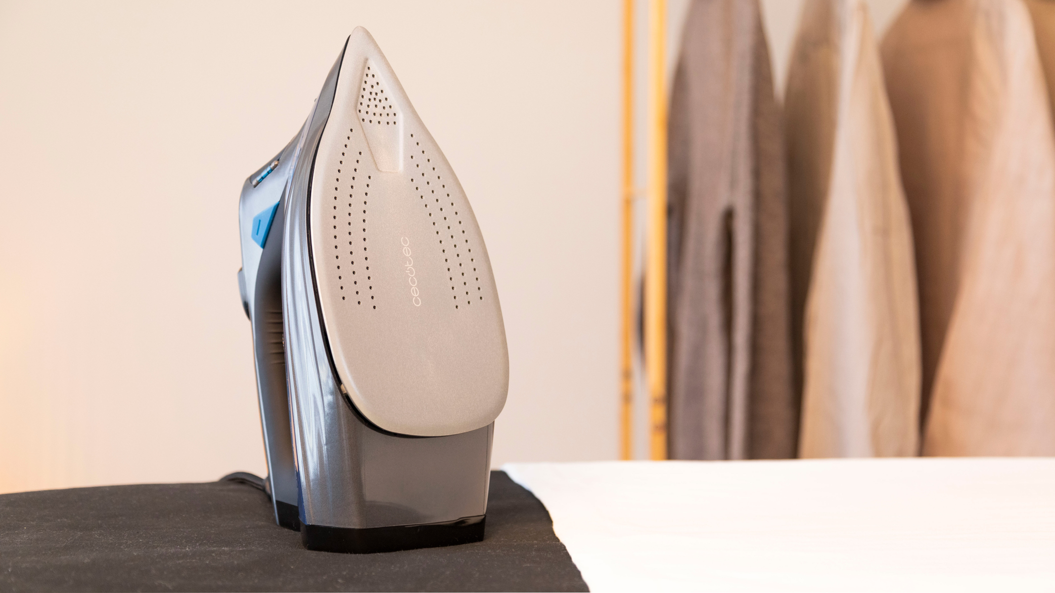 An iron with a grey soleplate on an ironing board.
