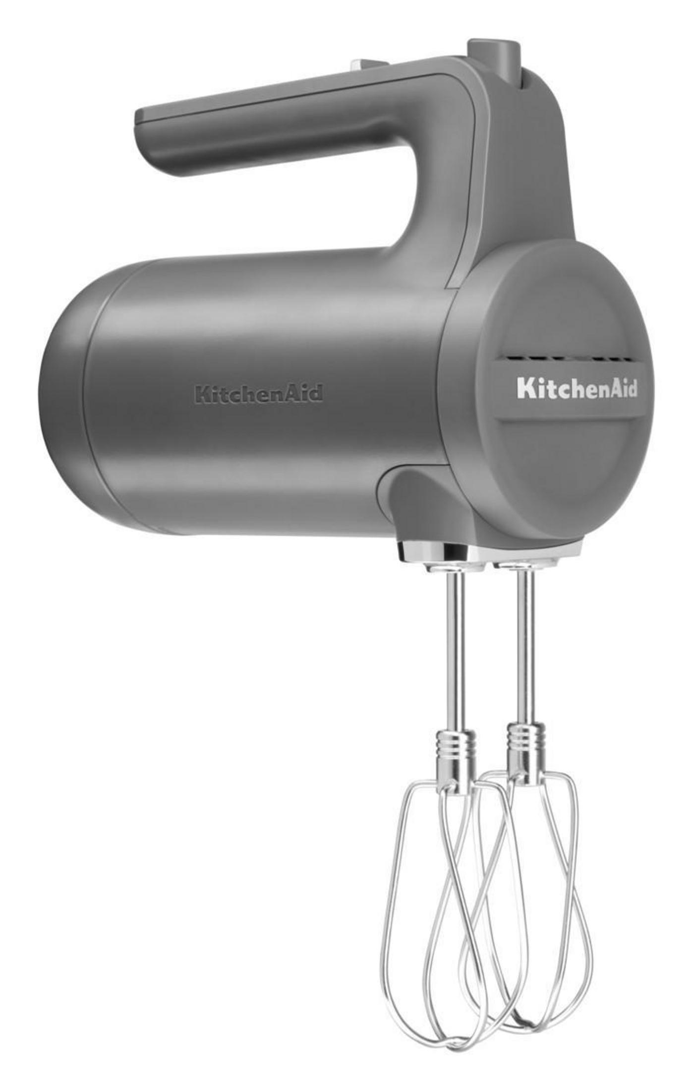 Beyaz zemin üzerinde, çırpıcıları olan gri bir KitchenAid el mikseri.