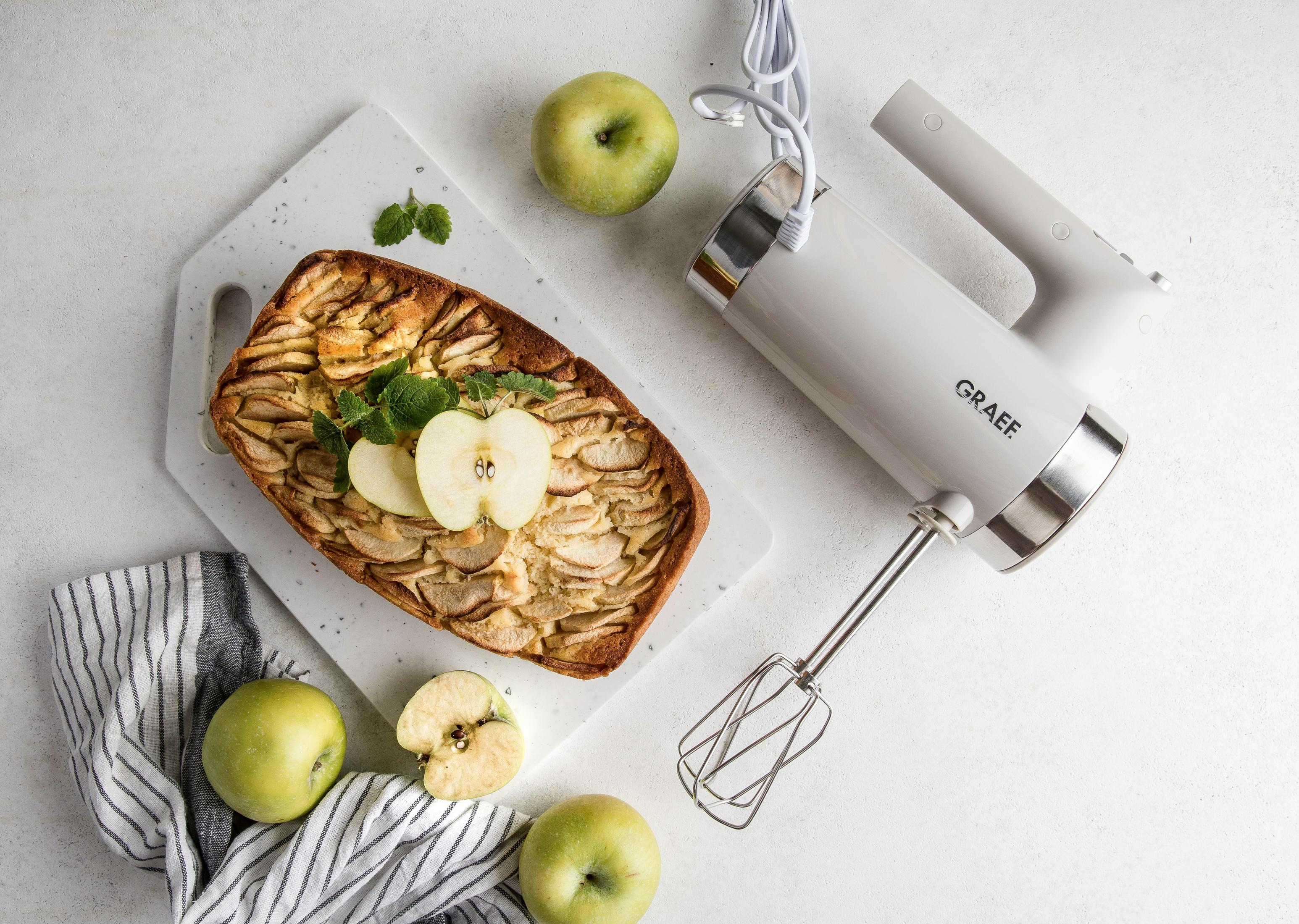 Appeltaart en mixer. Groene appels, witte mixer en snijplank. Witte achtergrond.
