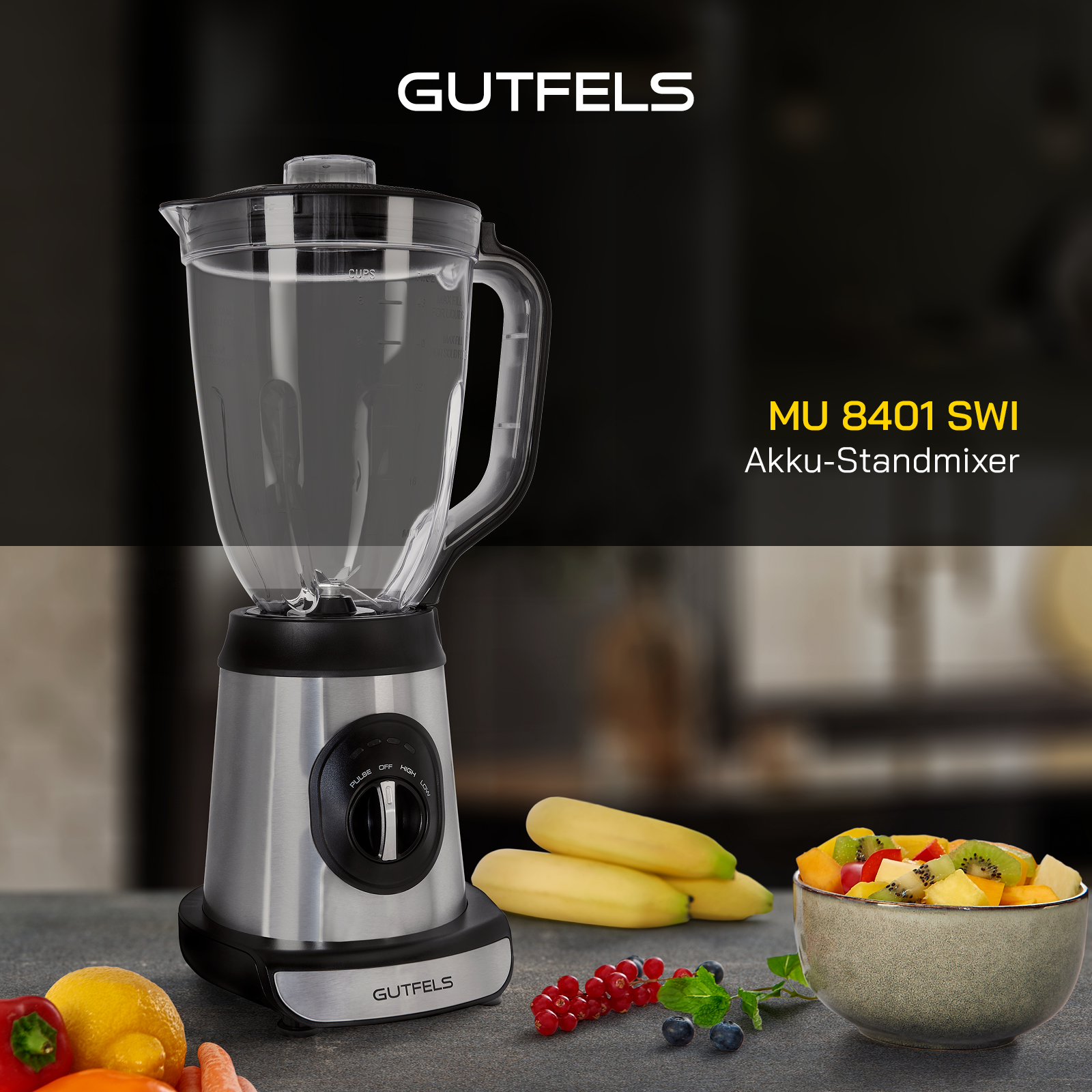Silberner und schwarzer Mixer mit Glasbehälter, Bananen und gemischten Früchten in einer Schüssel auf einer Theke.