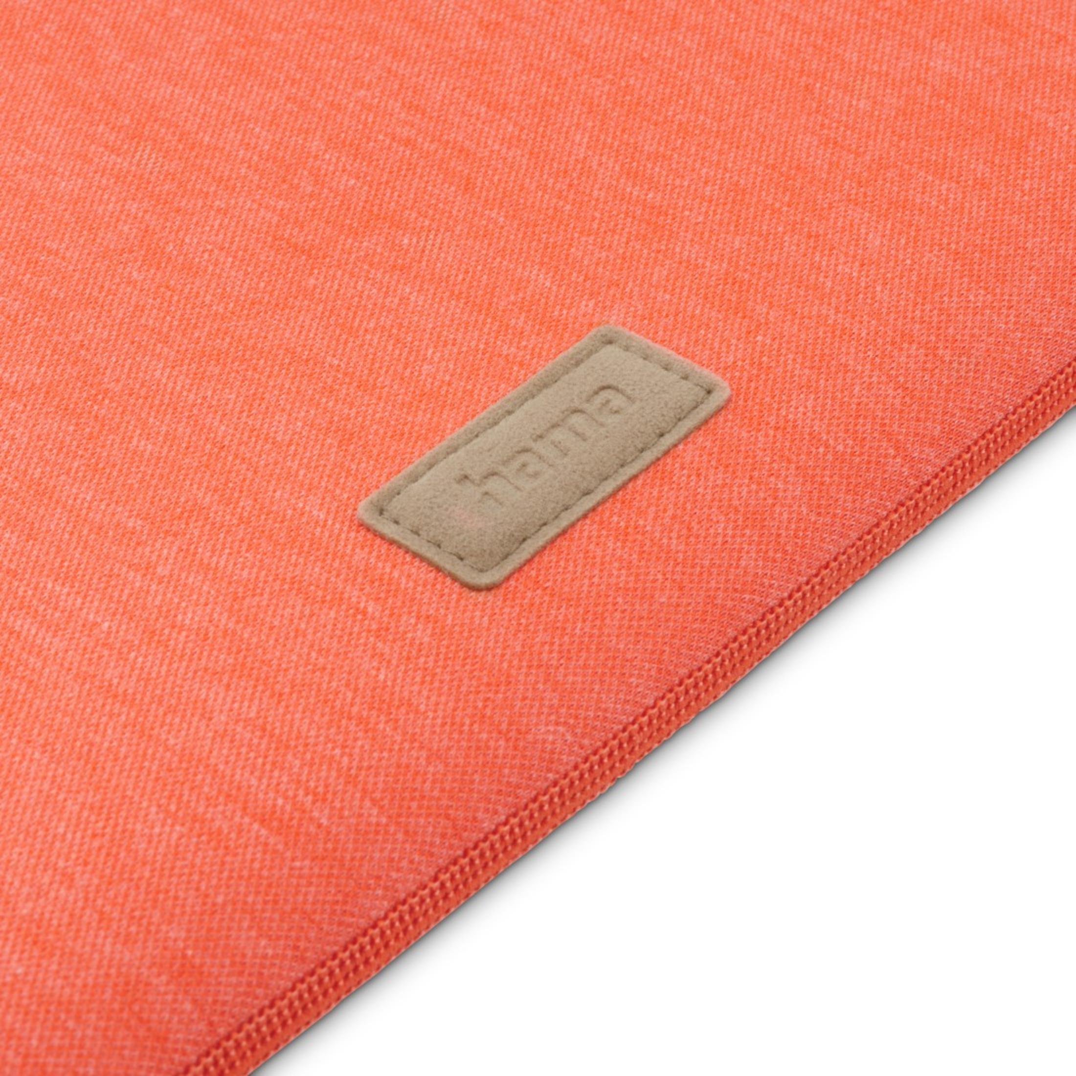 Nahaufnahme eines orangefarbenen Stoffes mit einem braunen Etikett mit der Aufschrift 'hama'.