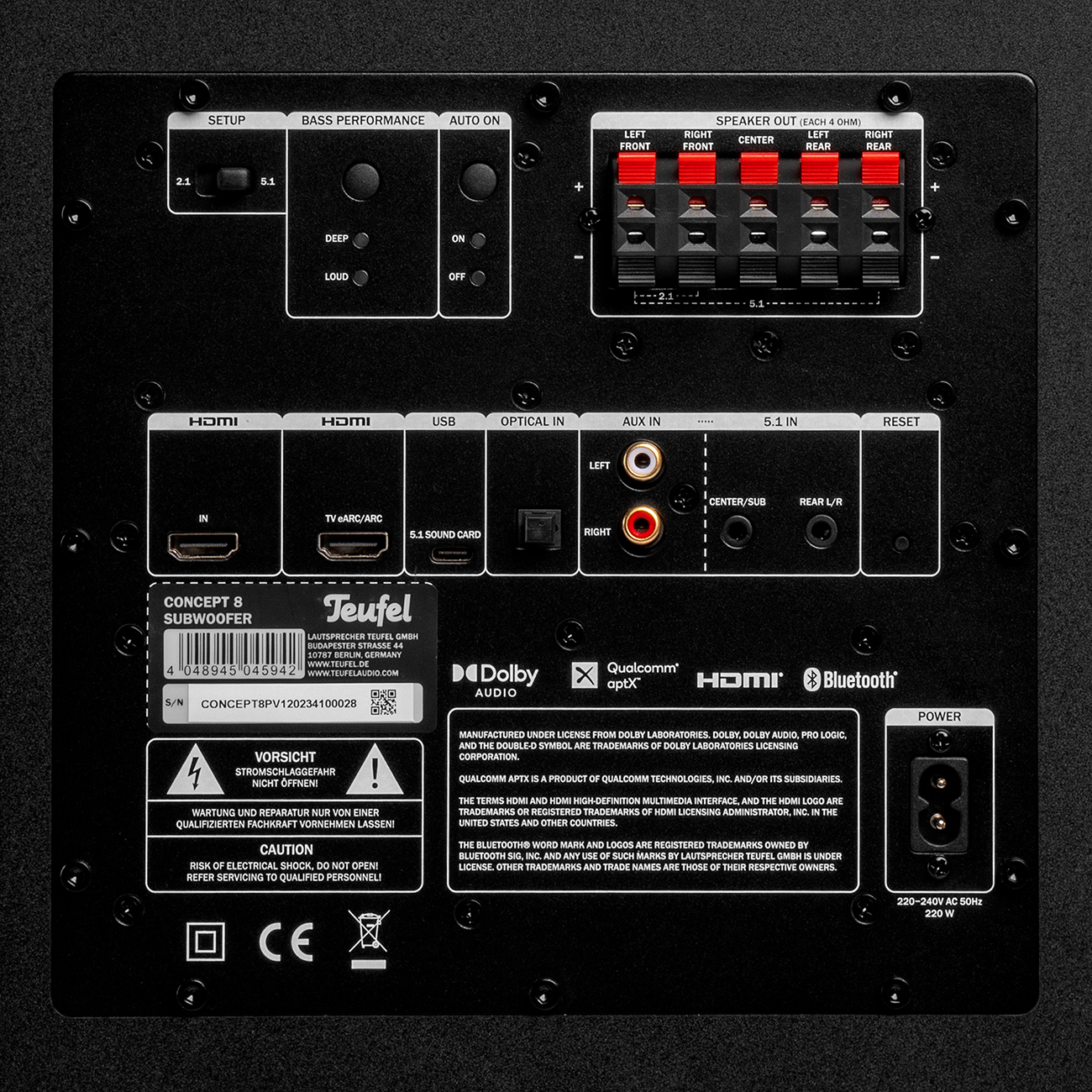 Schwarze Rückseite des Subwoofers mit verschiedenen Anschlüssen, Eingängen und Etiketten. Warnungen vorhanden.