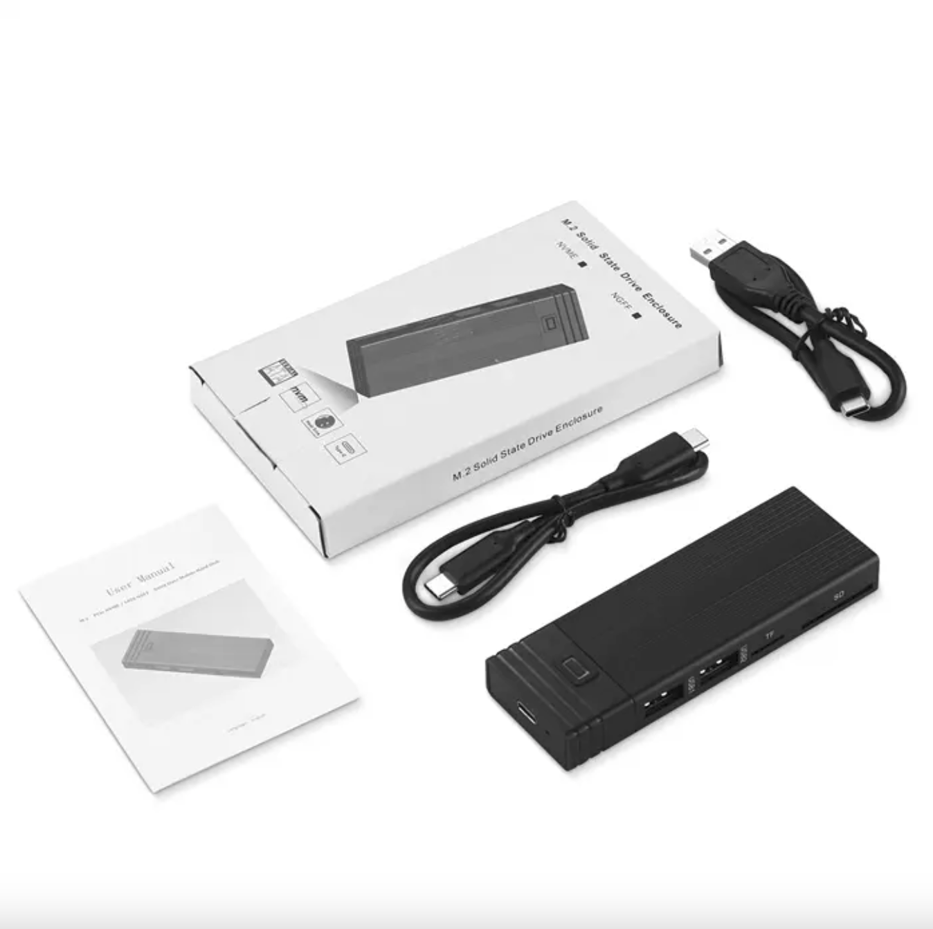 Obudowa dysku SSD M.2 z pudełkiem, kablami i instrukcją obsługi na białej powierzchni.