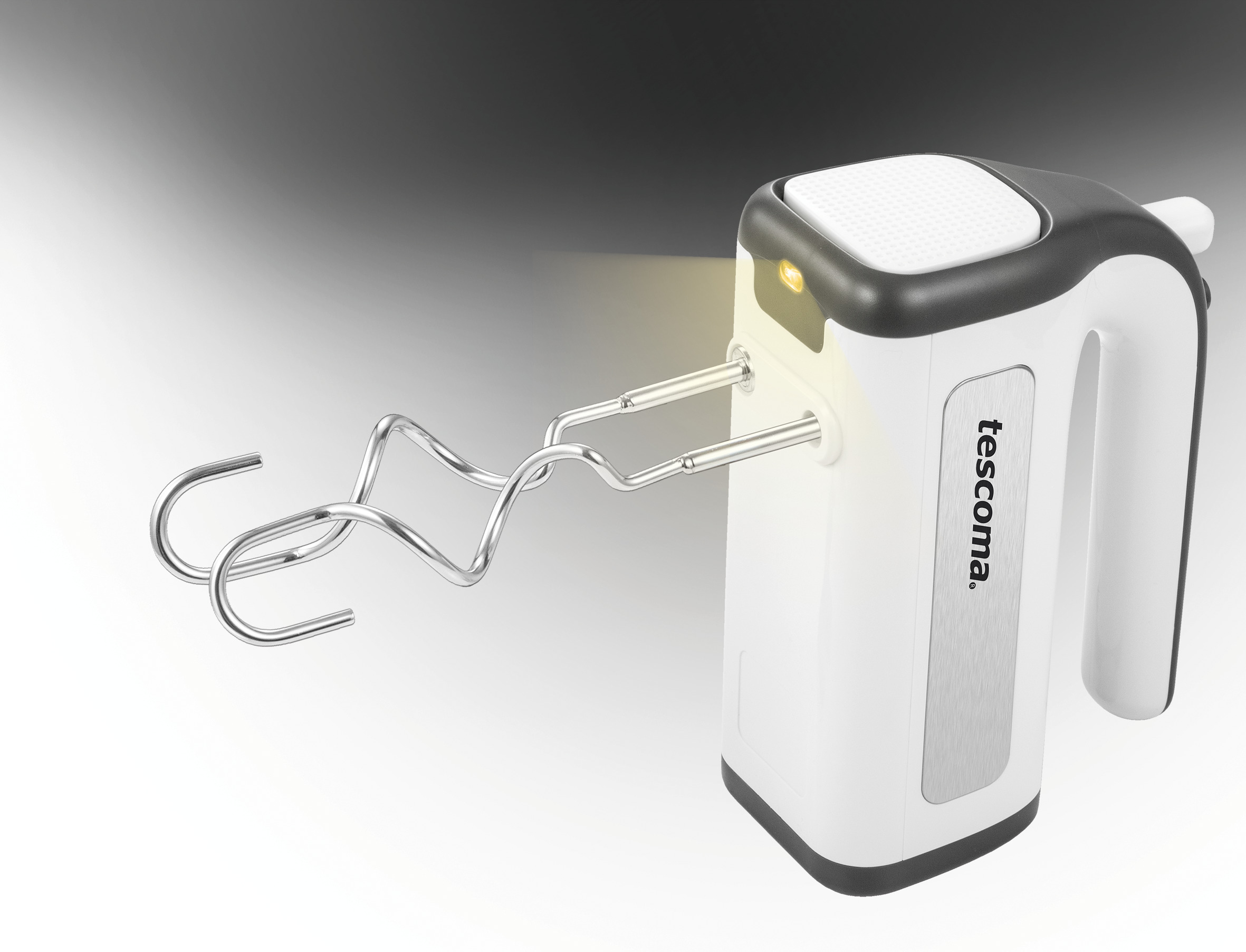 Weißer und schwarzer Tescoma Handmixer. Silberne Rührbesen ragen aus der Front. Licht beleuchtet den Mixer.