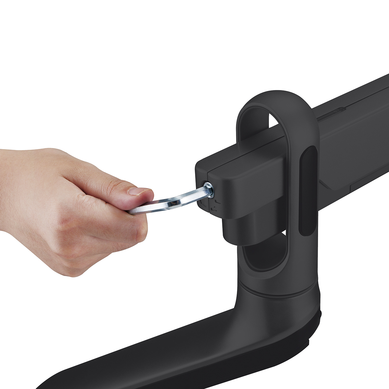 Eine Hand zieht mit einem Schraubenschlüssel eine Schraube an einem schwarzen Monitorarm fest.