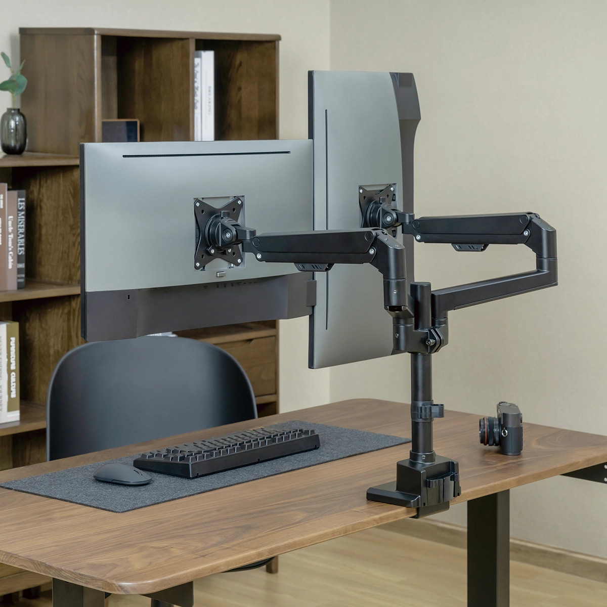 Computertisch mit zwei Monitoren und einem verstellbaren Arm.