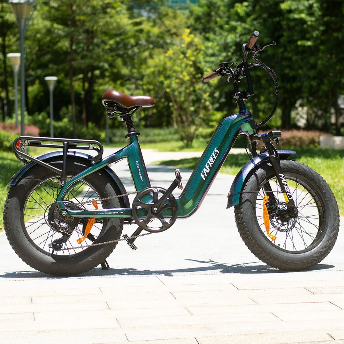 Grünes und schwarzes FAFREES E-Bike auf einem Weg mit grünen Bäumen. Das Fahrrad hat breite Reifen.