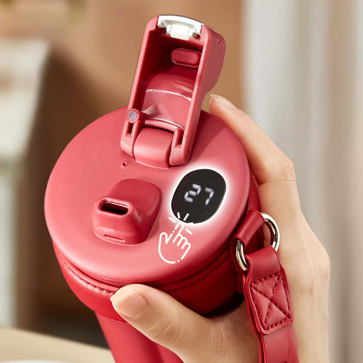 Roter Wasserflaschenaufsatz mit Digitalanzeige zur Temperatur. Hand hält die Flasche.