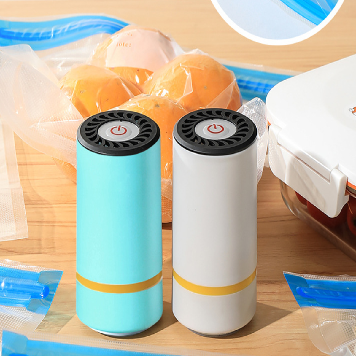 Zwei Vakuumiergeräte, blau und weiß, mit Orangen in einem Plastikbeutel und Text 'date:' darauf.