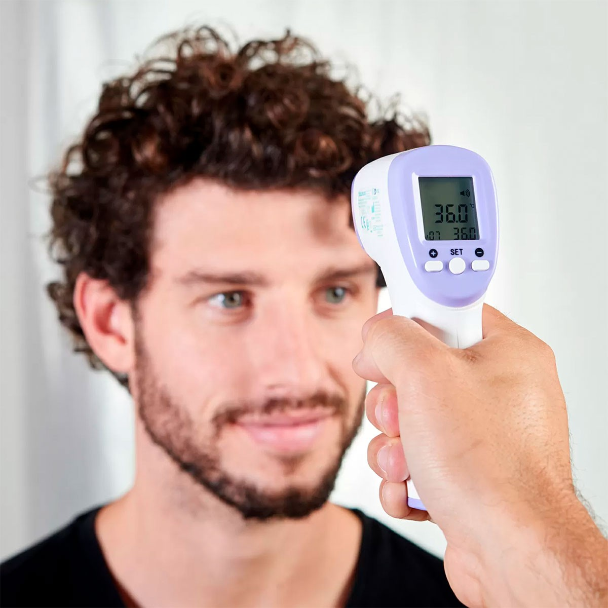 Una persona prende la temperatura di un uomo con un termometro digitale. La lettura è 36,0°C.