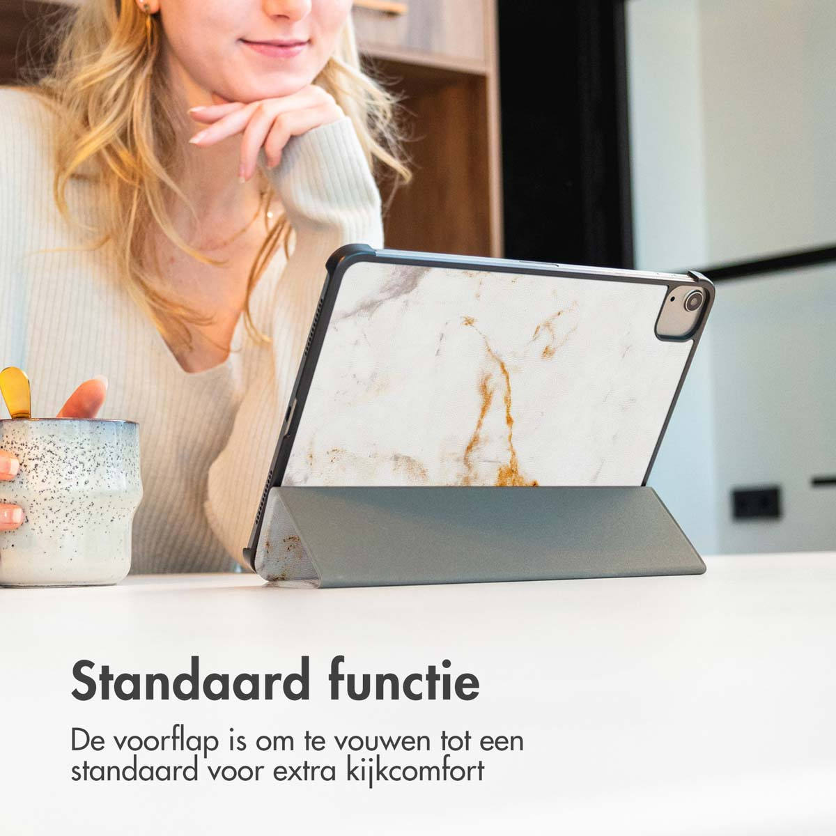 Une femme utilise une tablette avec un étui en marbre. La tablette est sur un support.