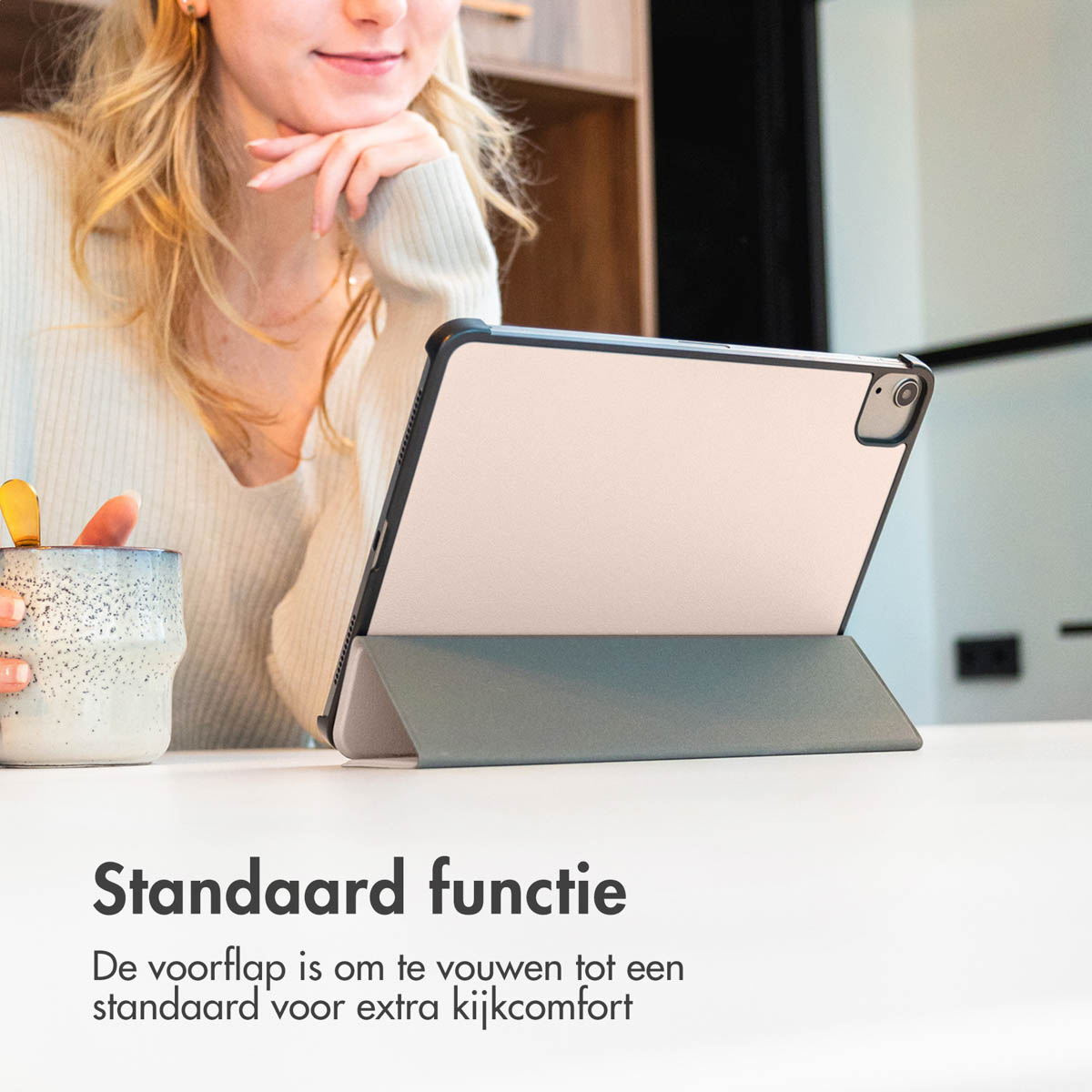 Een vrouw met een tablet in een hoesje op een tafel. Tekst: Standaardfunctie.