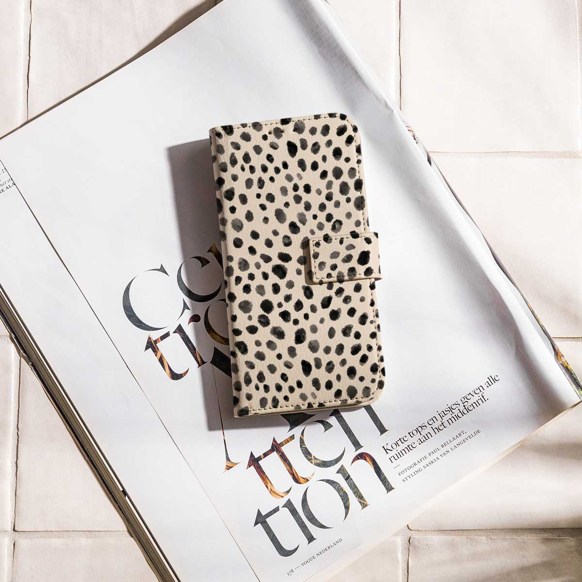 Telefoonhoesje met een bruin en zwart gevlekt patroon op een magazine.