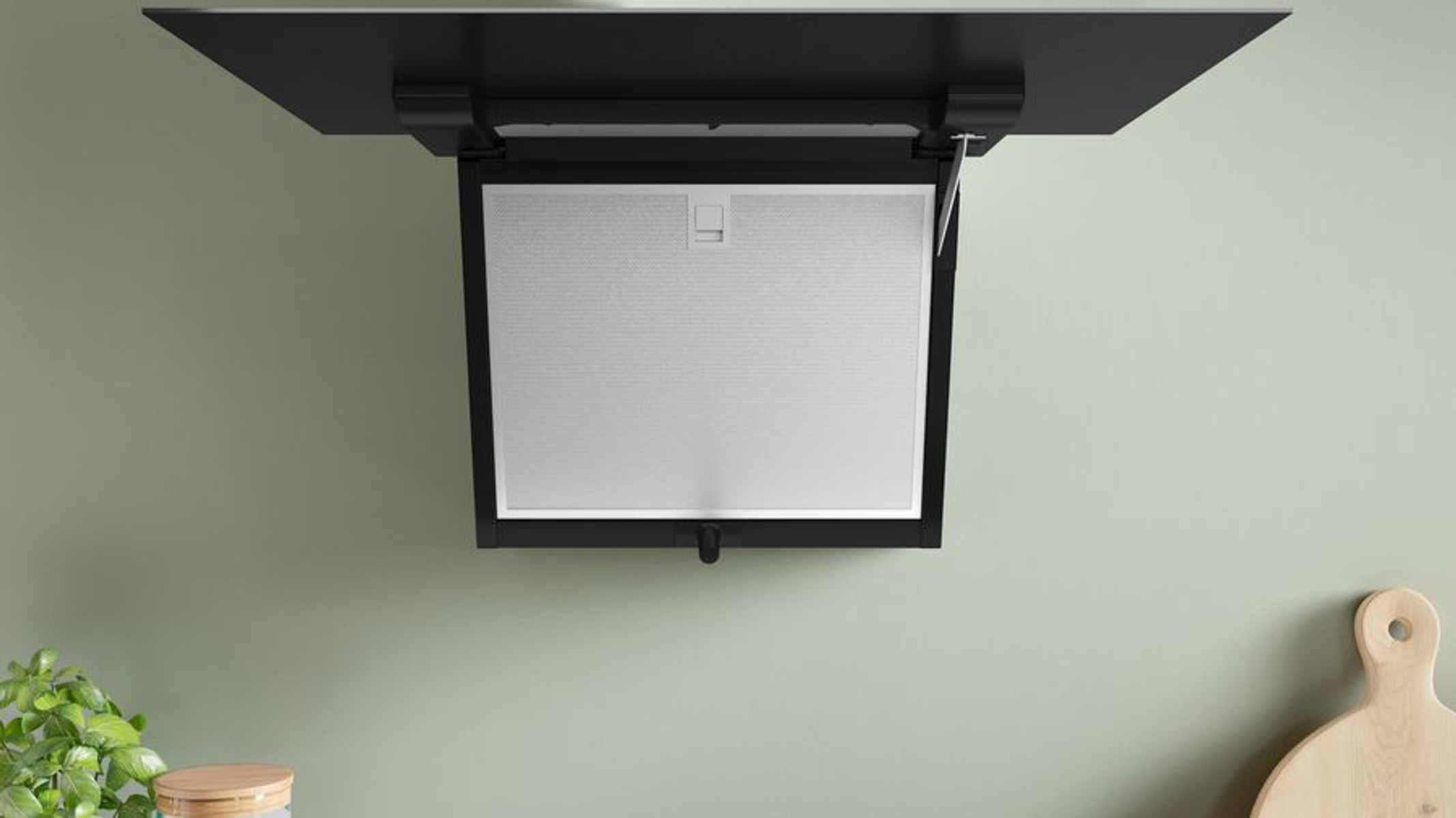 Czarny okap zamontowany na zielonej ścianie. Filtr jest widoczny.