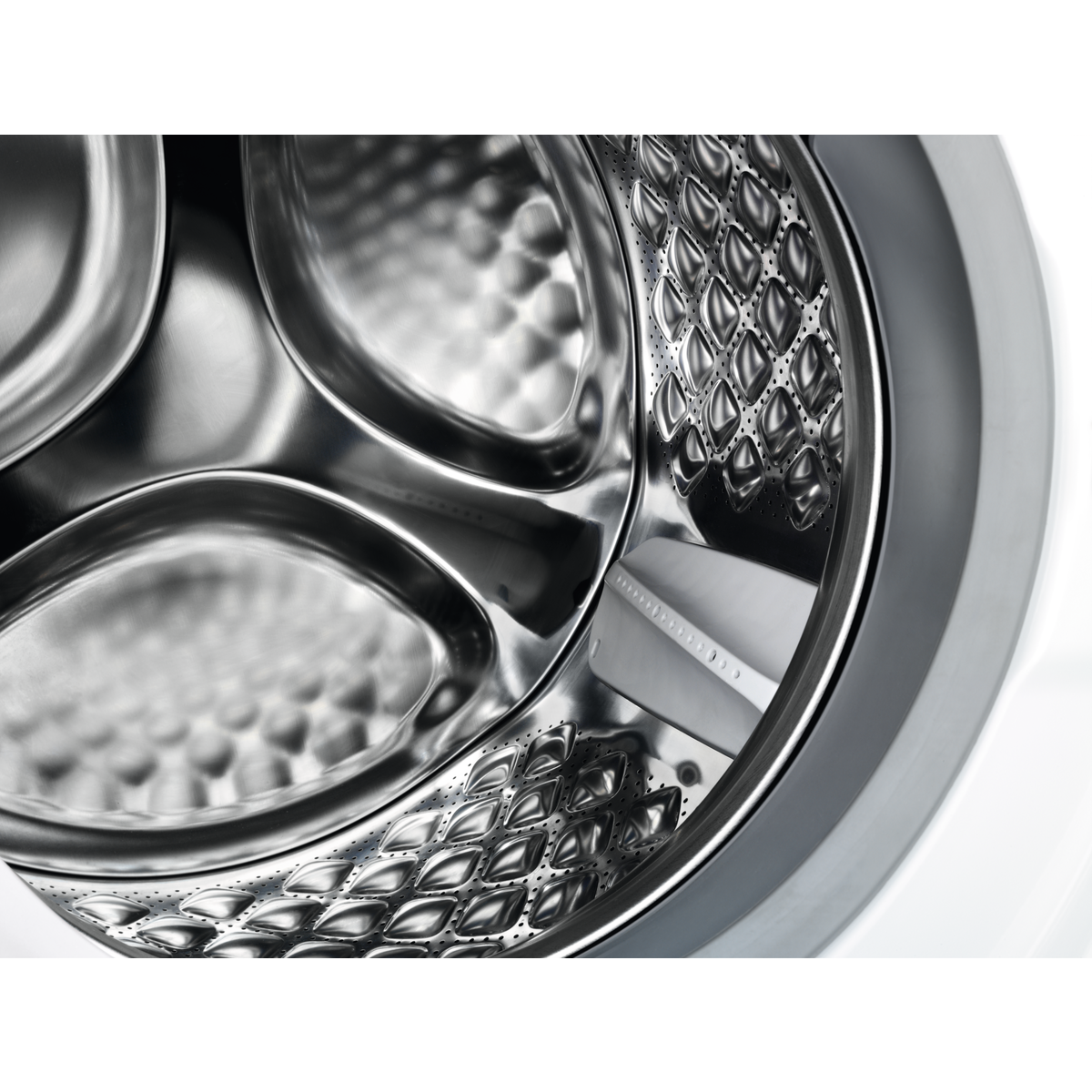 Zbliżenie bębna pralki, pokazujące konstrukcję ze stali nierdzewnej.