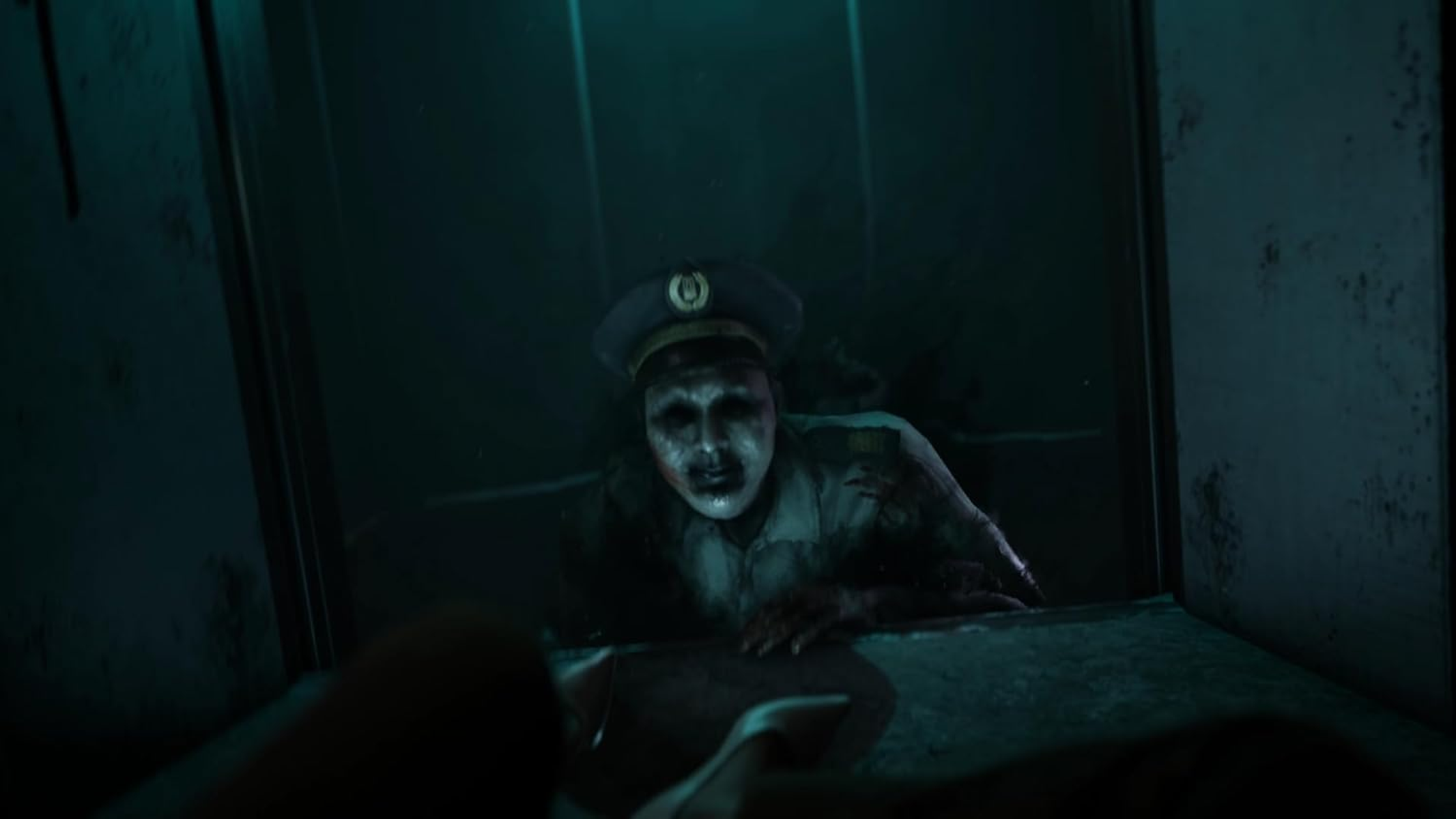 Przerażający zombie wyglądający przez okno. Ciemna, zielono zabarwiona scena. Zombie jest w centrum.