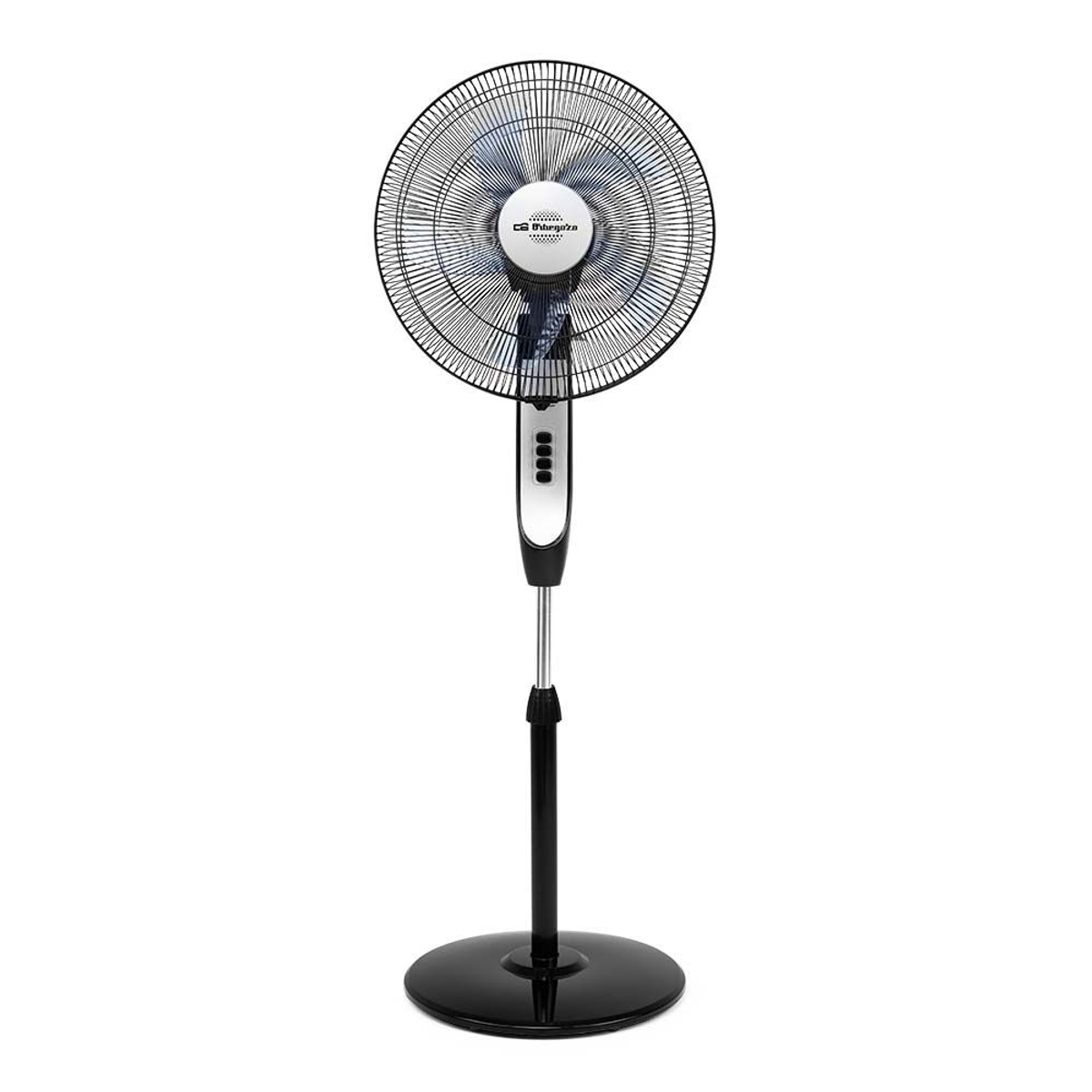 Un ventilador de pie negro y plateado sobre un fondo blanco.