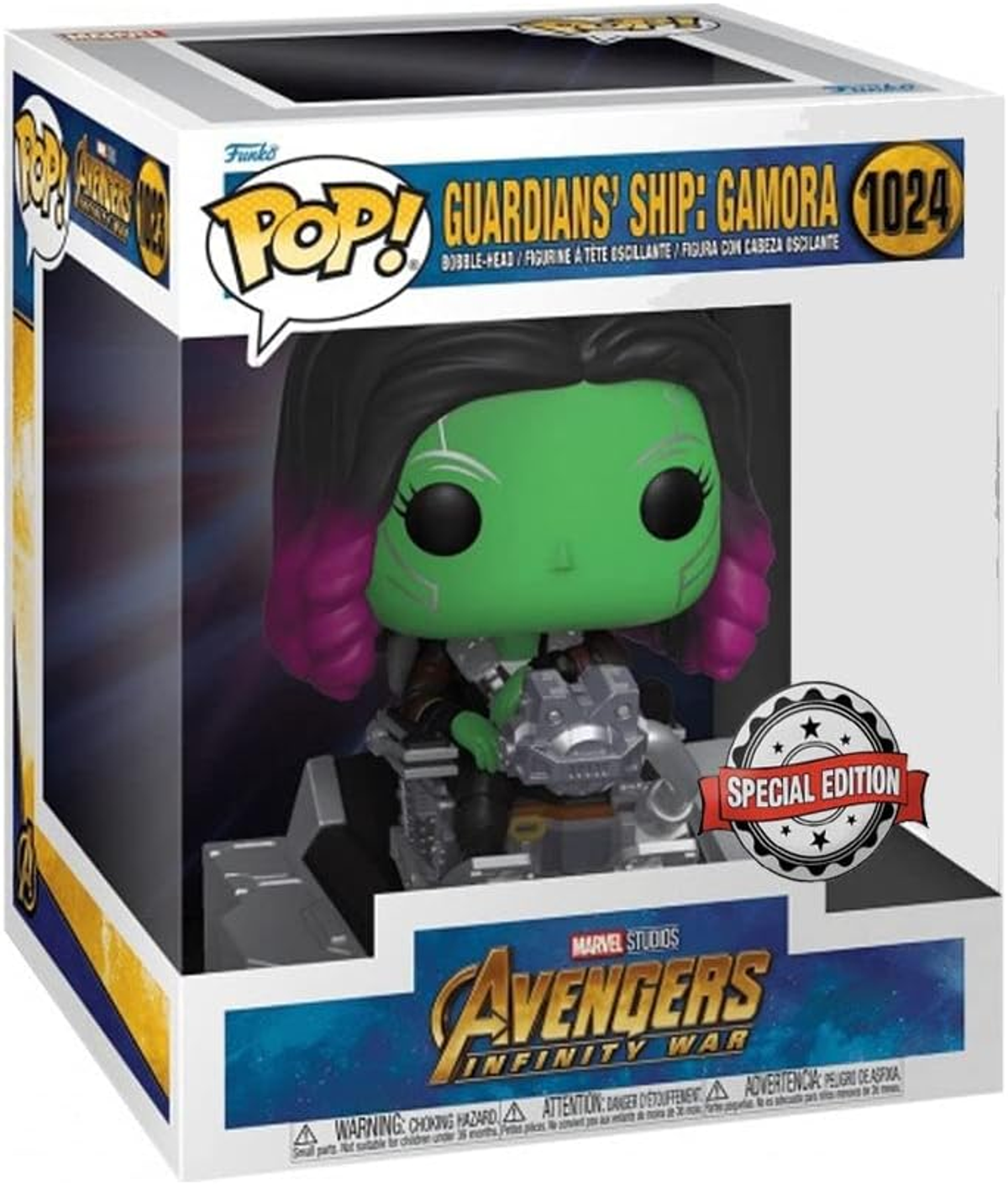 Figura de Gamora en una caja, de Avengers. La figura es verde con pelo rosa y un dispositivo plateado.