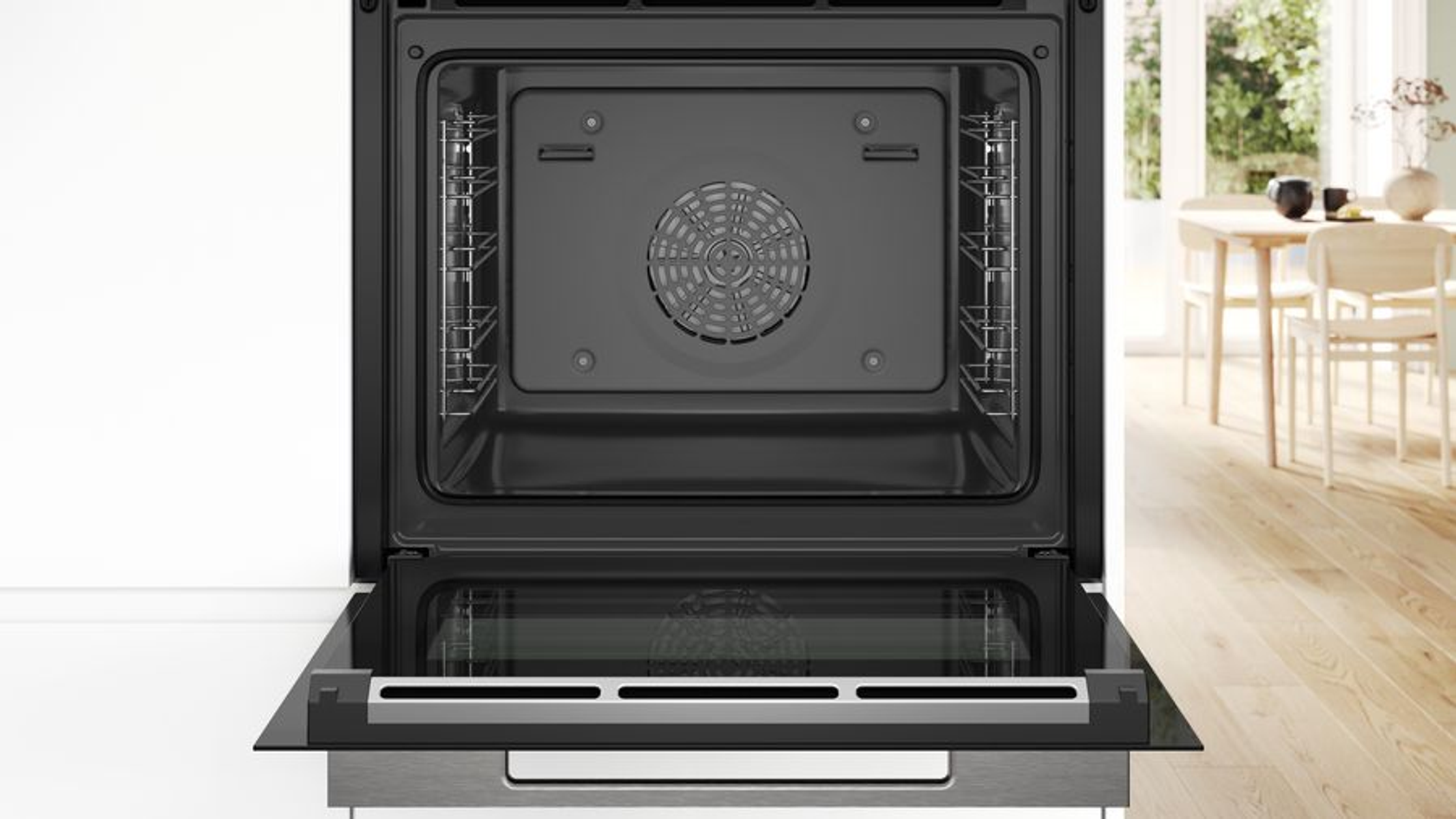 Horno abierto con rejillas dentro. Un ventilador en la parte trasera. Fondo con comedor.