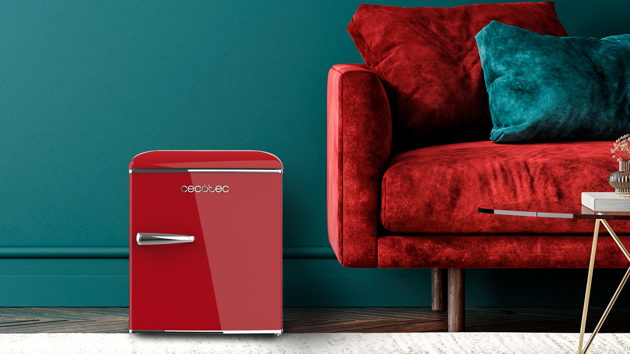 Un mini-frigo rosso con maniglia argentata, accanto a un divano.