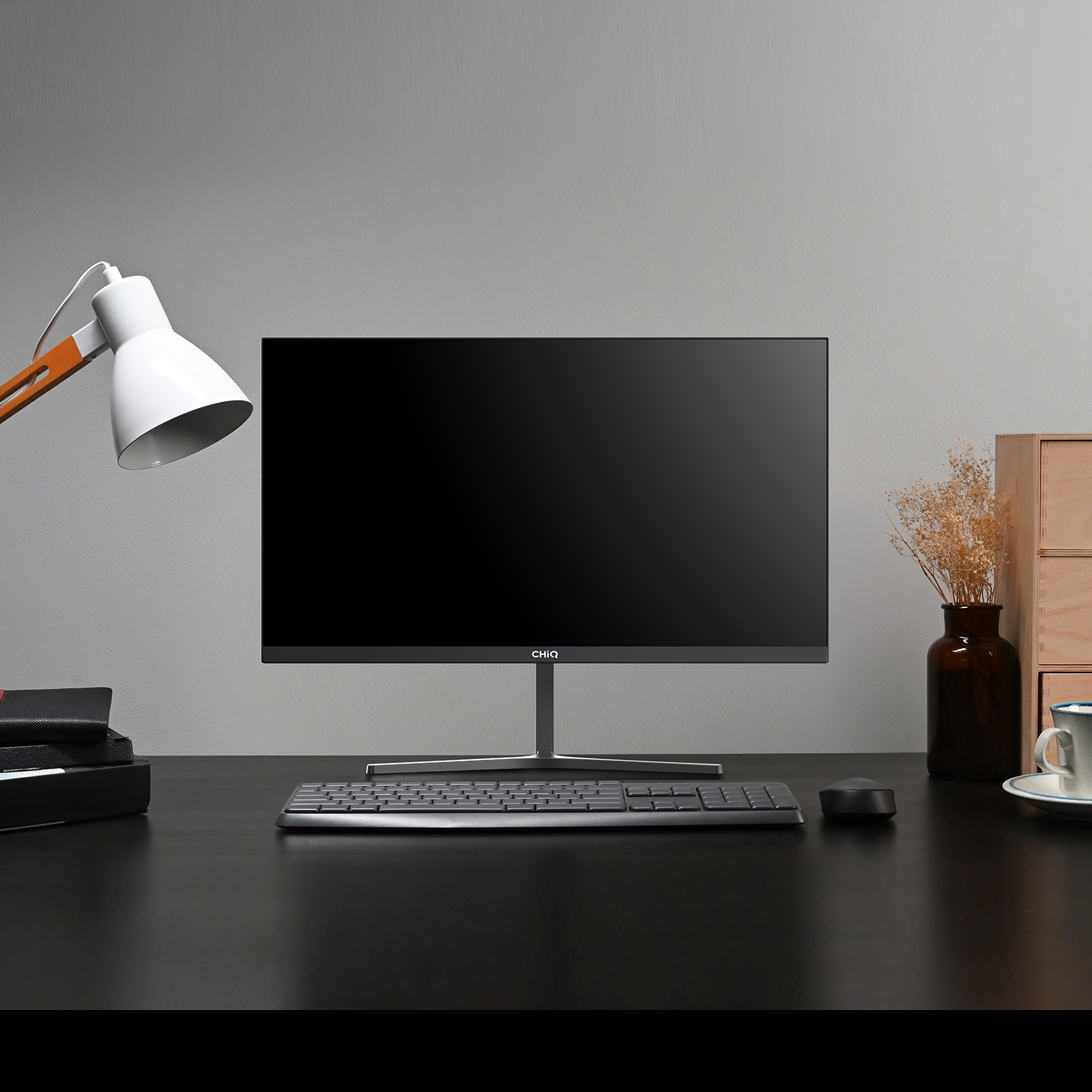 Konfiguracja komputera z monitorem CHiQ, klawiaturą, myszką i lampą.