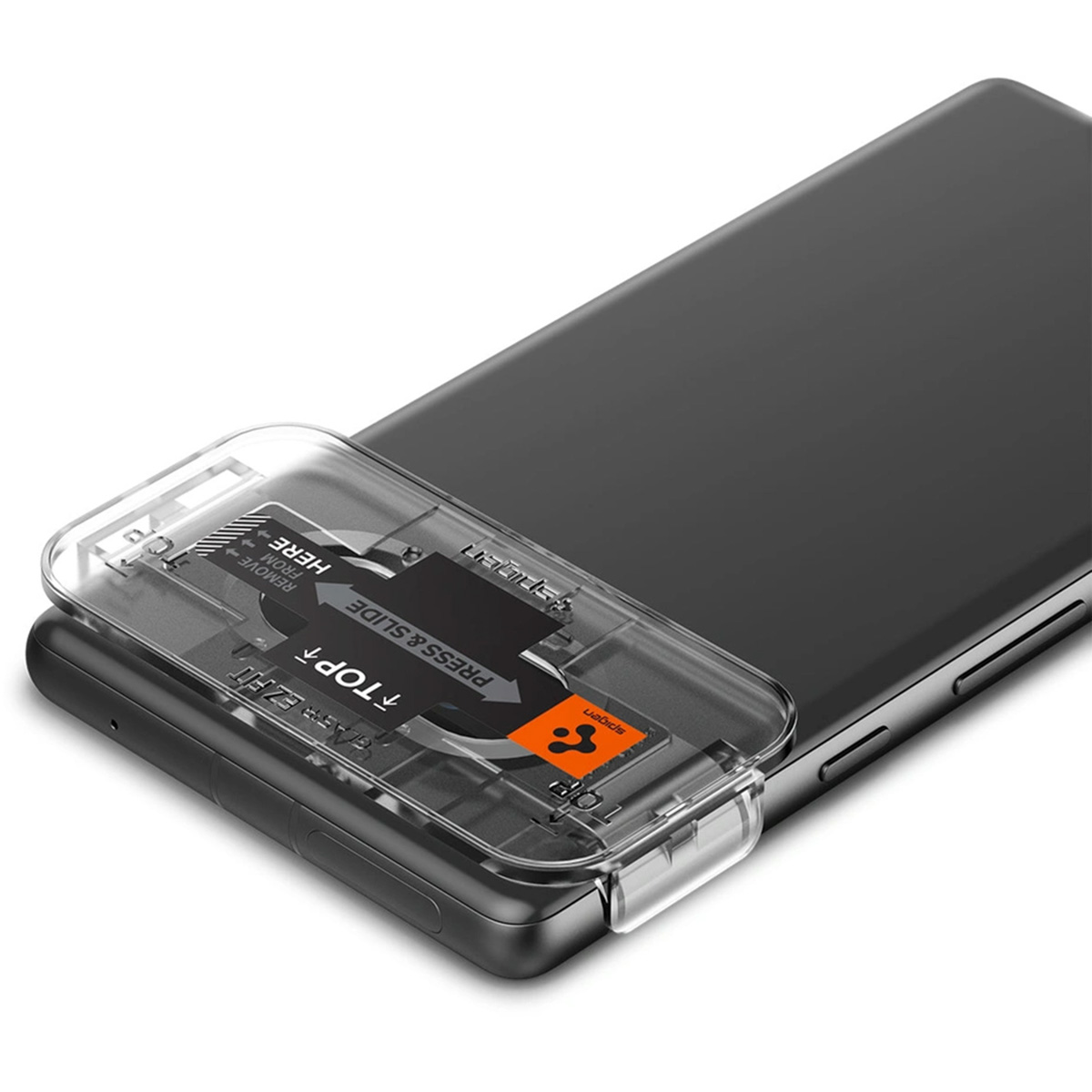 Un téléphone repose sur une surface avec un outil d'application de protection d'écran transparent.