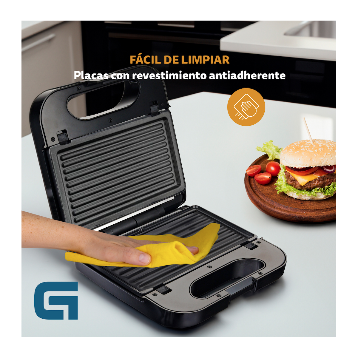 Una persona limpia una sandwichera negra con un paño amarillo.