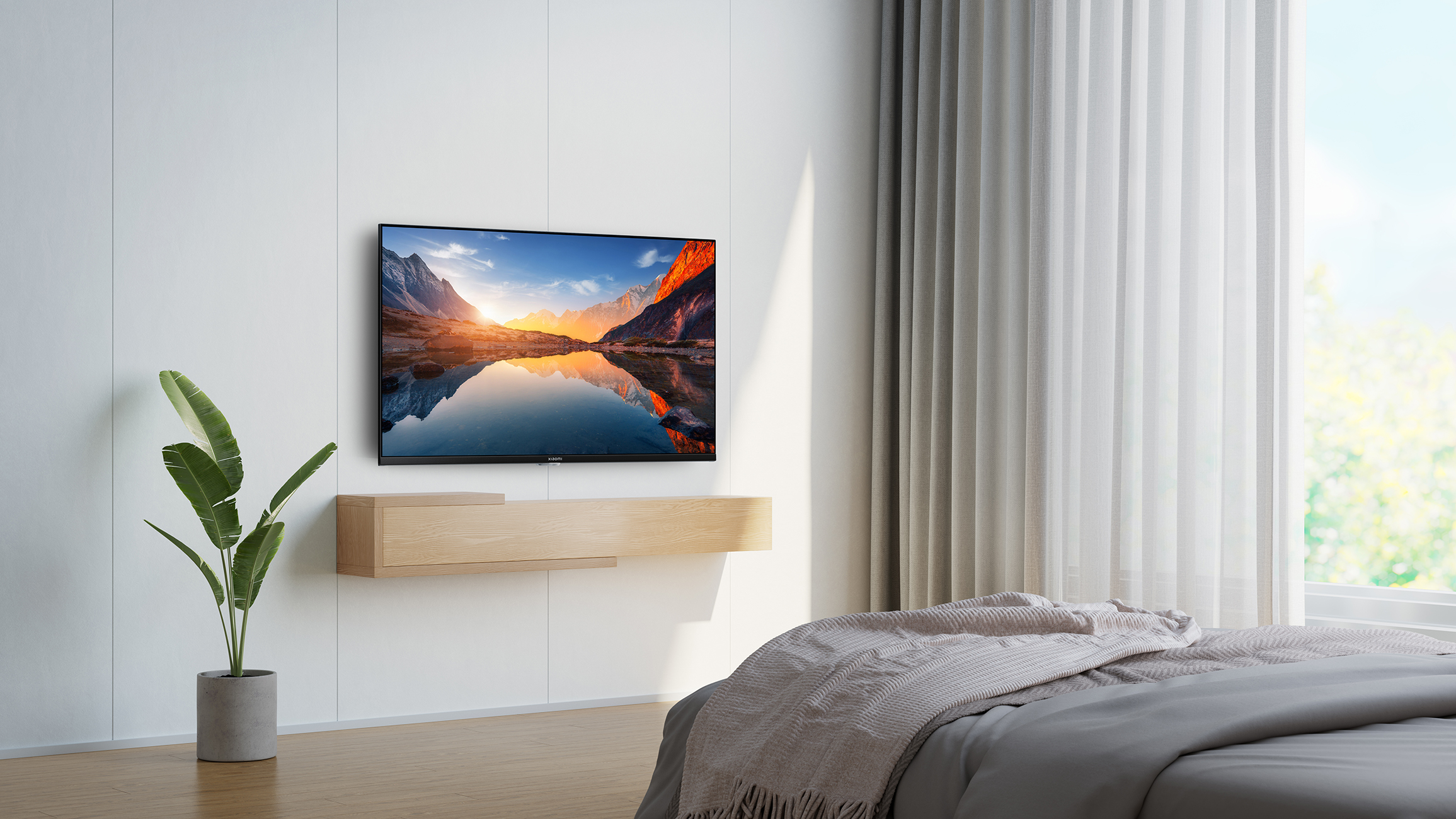 Een tv aan een witte muur met een moderne zwevende plank eronder, een bed en raam op de achtergrond.