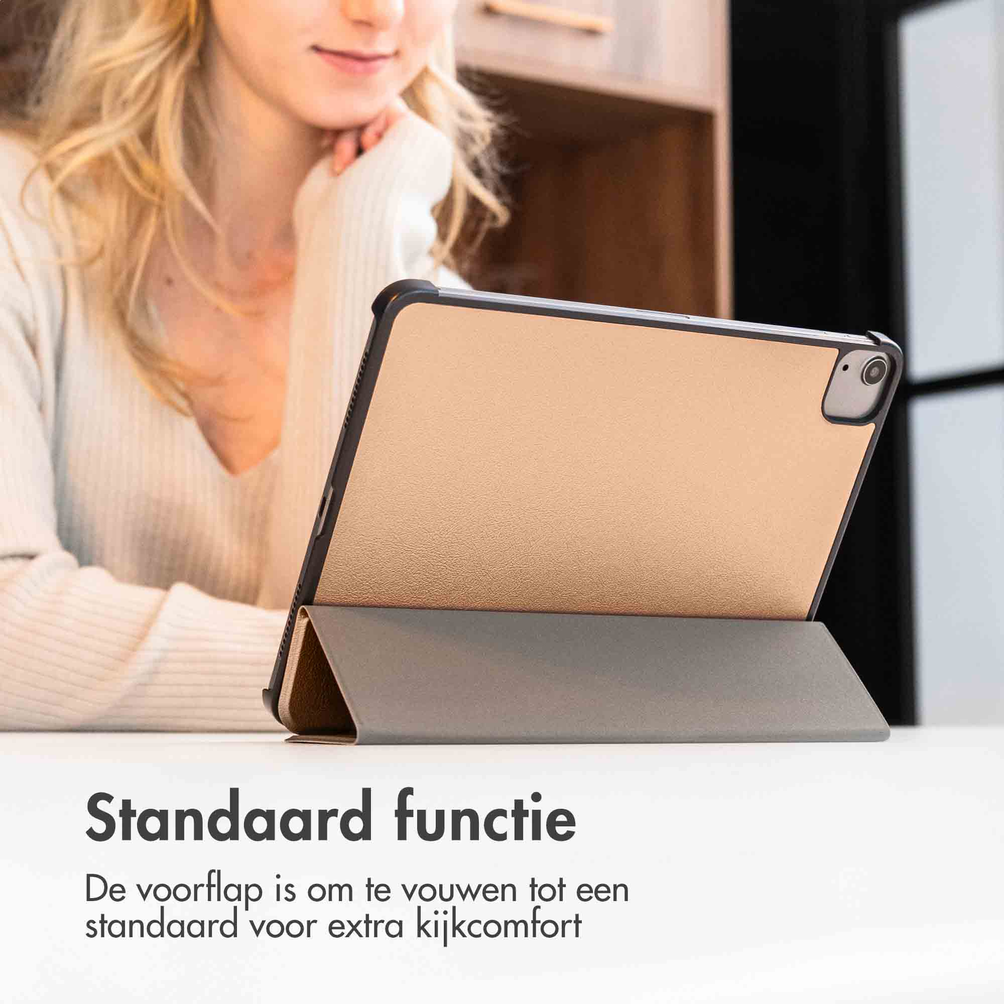 Vrouw die een gouden tablet met een standaard gebruikt.