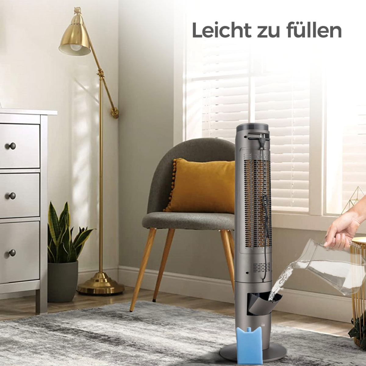 Ein grauer Luftkühler wird mit Wasser gefüllt, im Hintergrund ein gelbes Kissen und eine goldene Lampe.