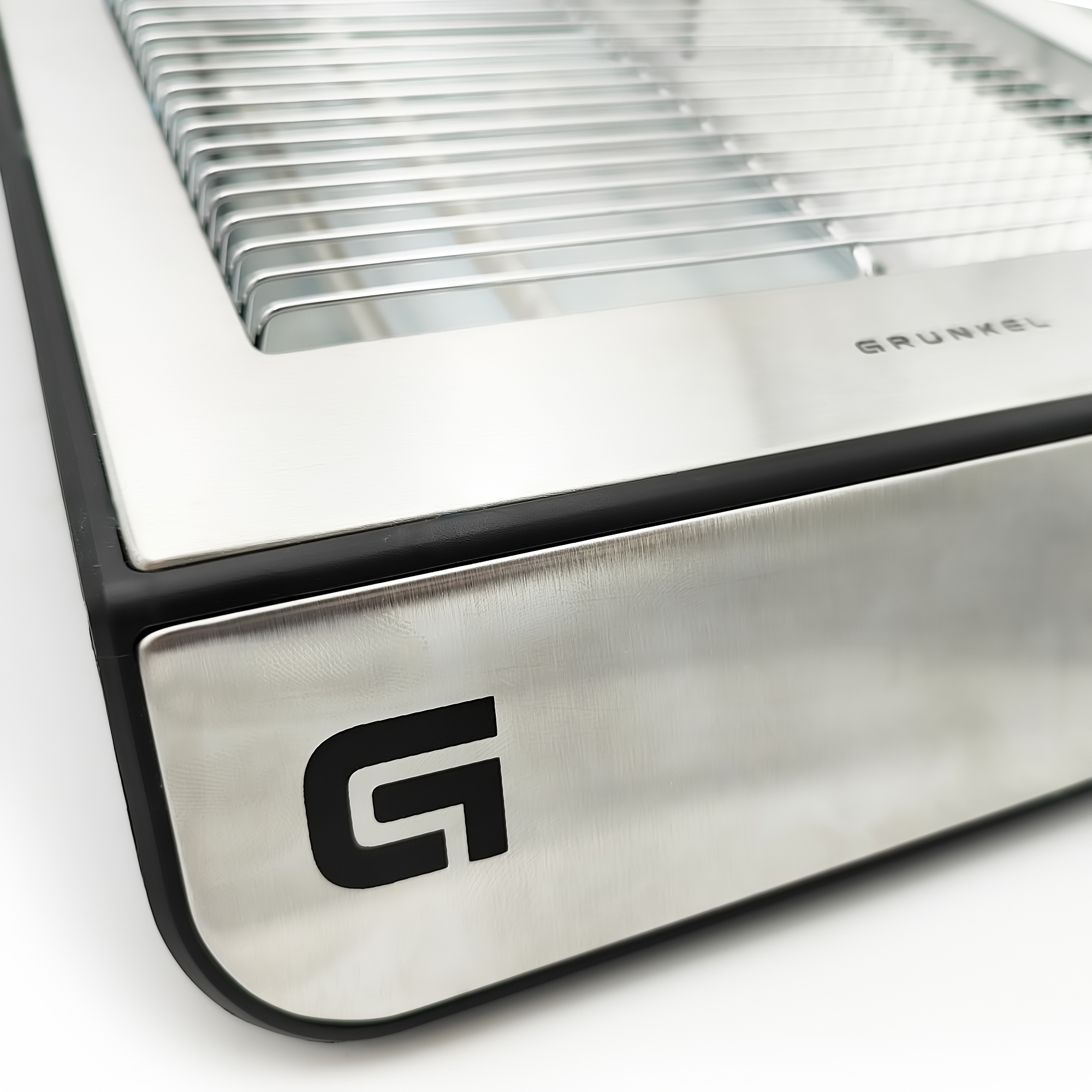 Primer plano de una parrilla de metal plateado y negro con la palabra GRUNKEL.
