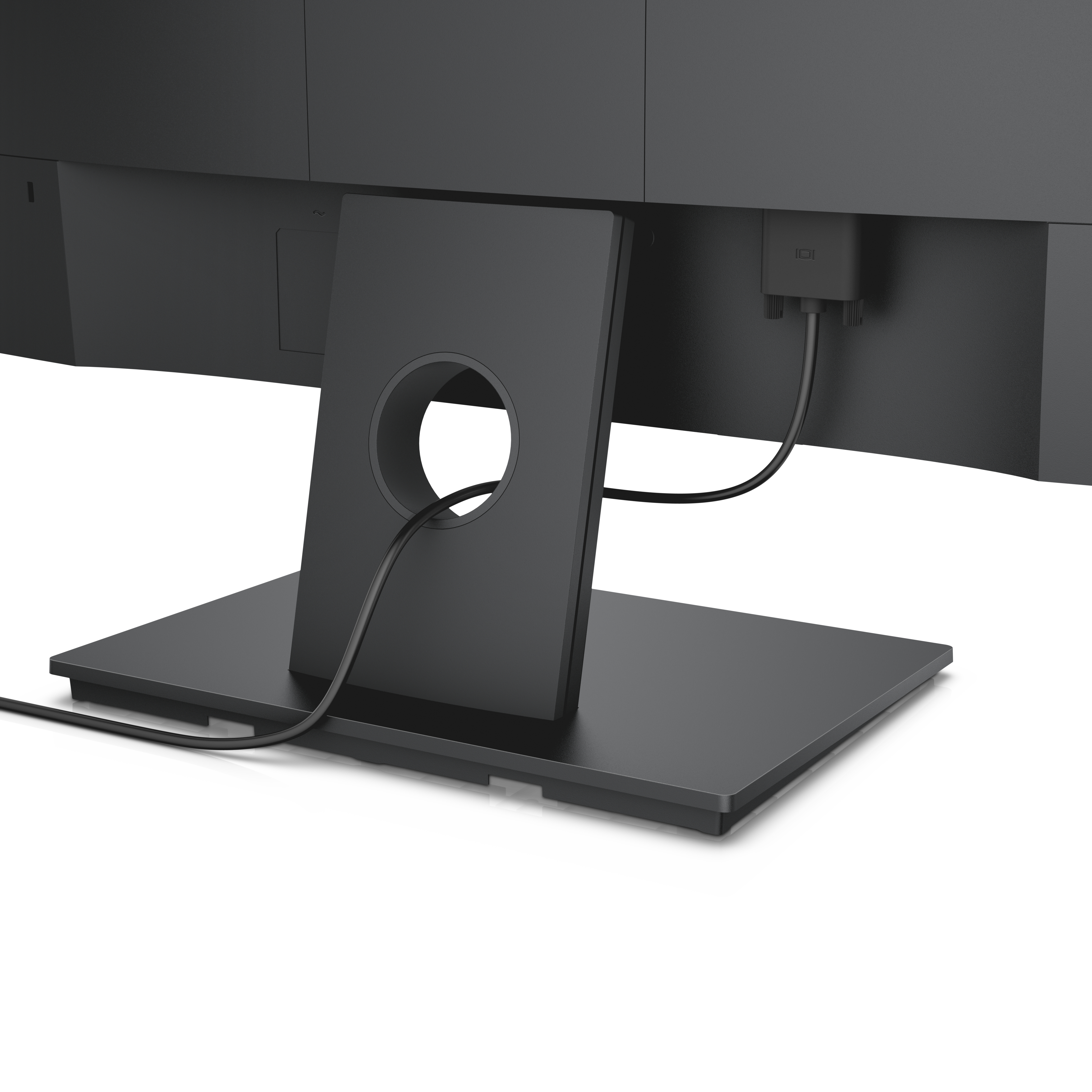 Primer plano de la parte trasera de un monitor de computadora negro, que muestra el soporte y los cables.