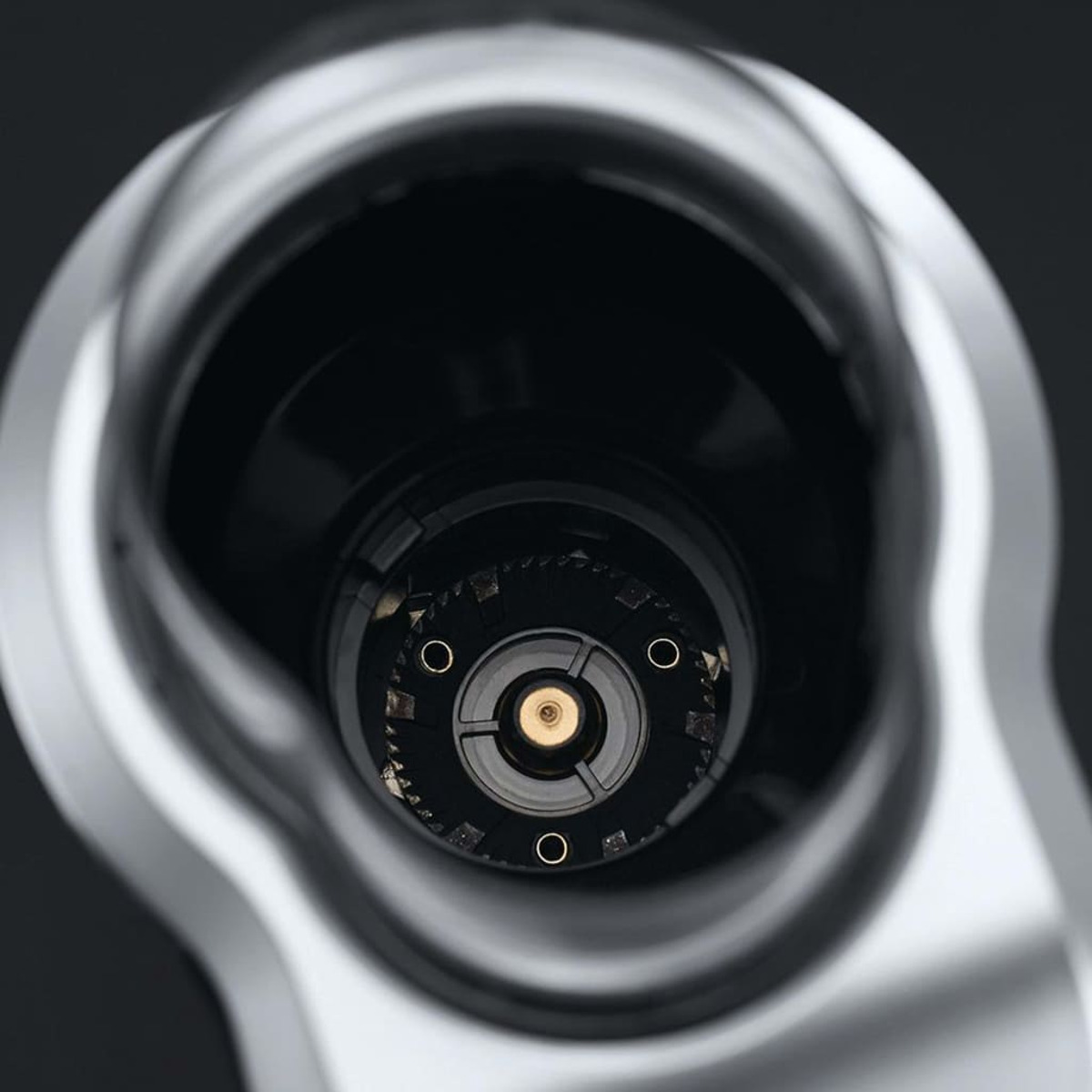 Wnętrze młynka. Czarne wnętrze. Okrągły design z centralnym, złotym elementem.