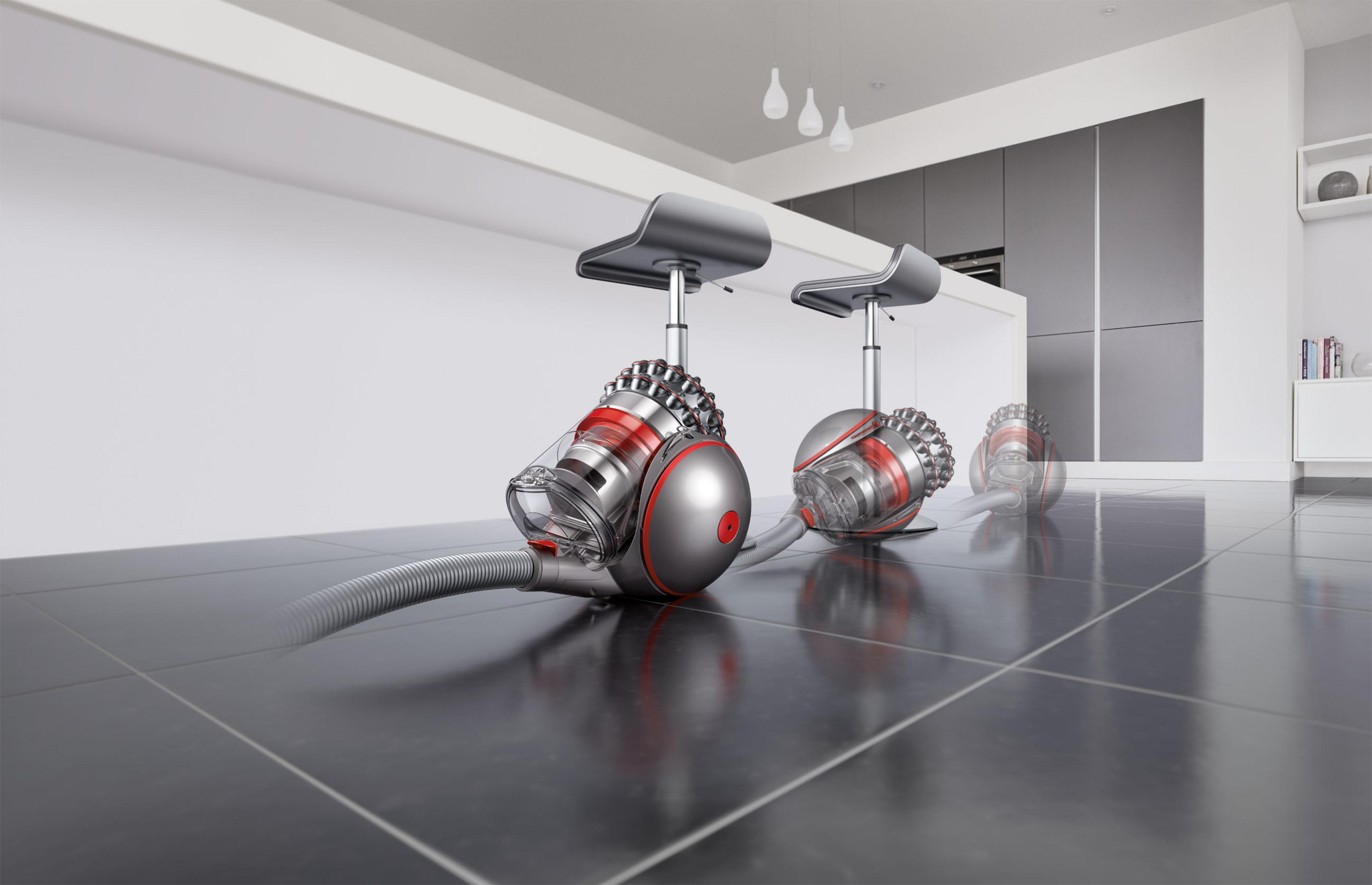 Fayanslı bir zeminde, iki tabure ve beyaz bir tezgahın yanında bir Dyson elektrikli süpürgesi.