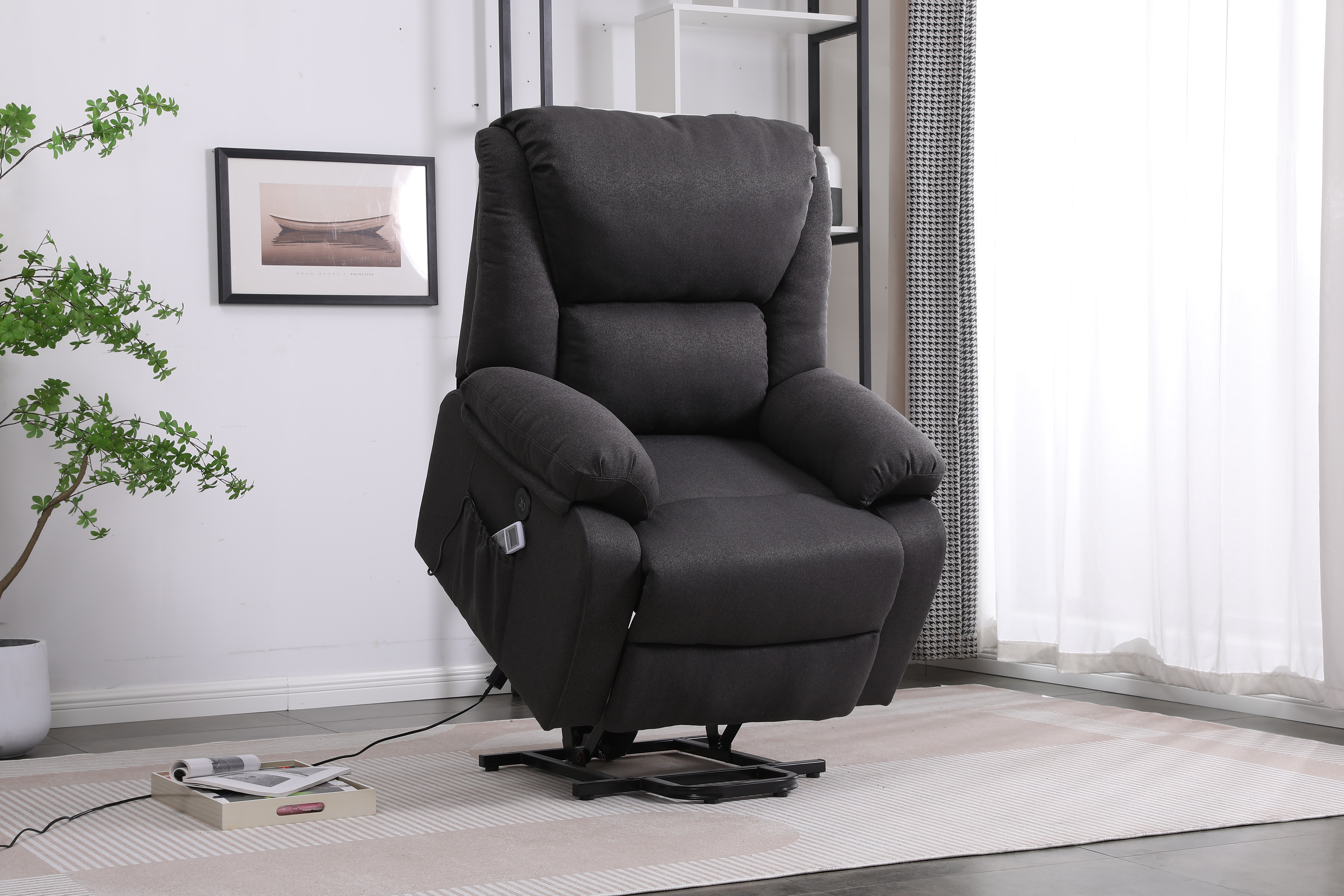 Sillón reclinable gris oscuro en una habitación. Un cuadro y una planta al fondo.