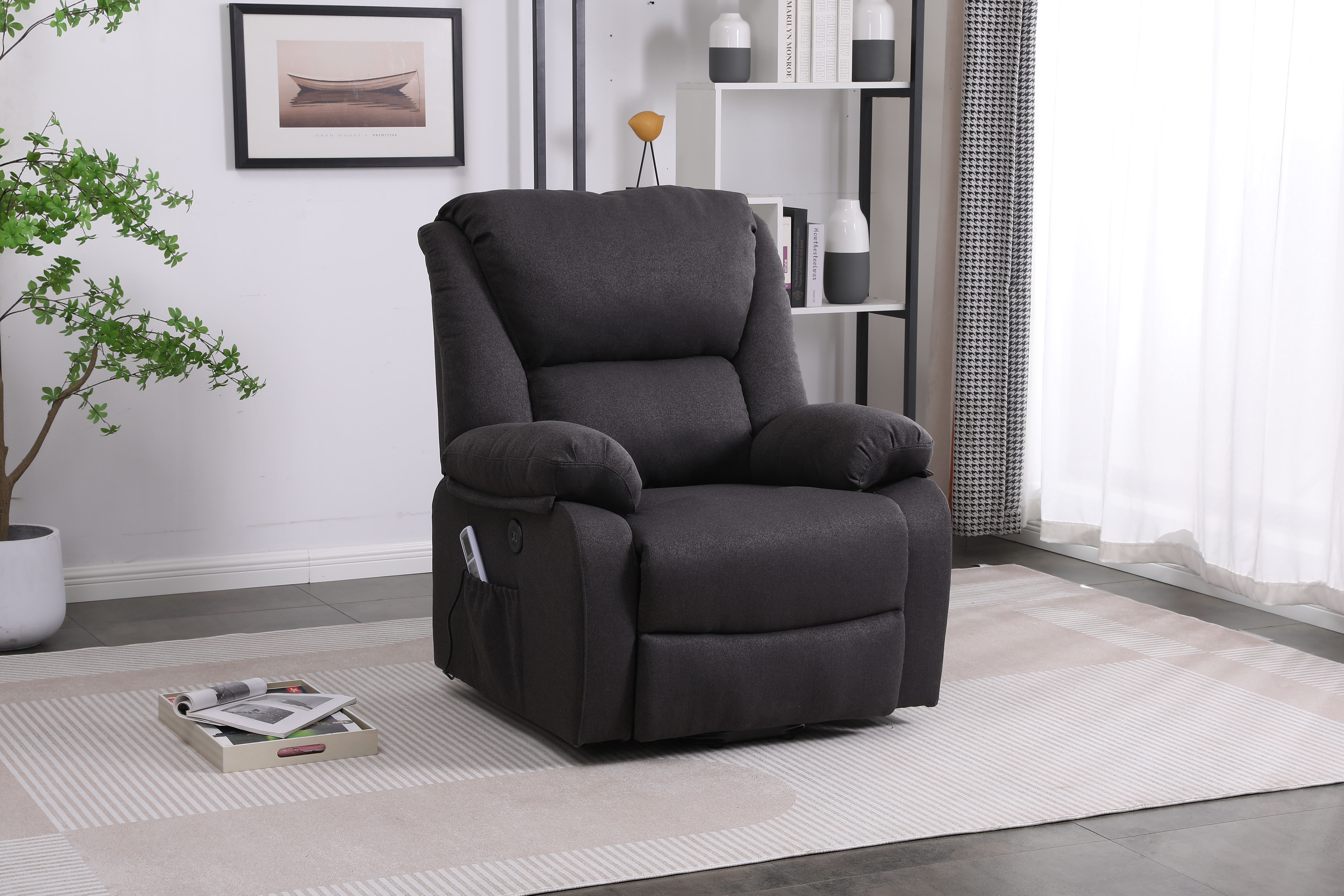 Sillón reclinable gris oscuro en una habitación. Un cuadro en la pared y una ventana con cortinas en el fondo.