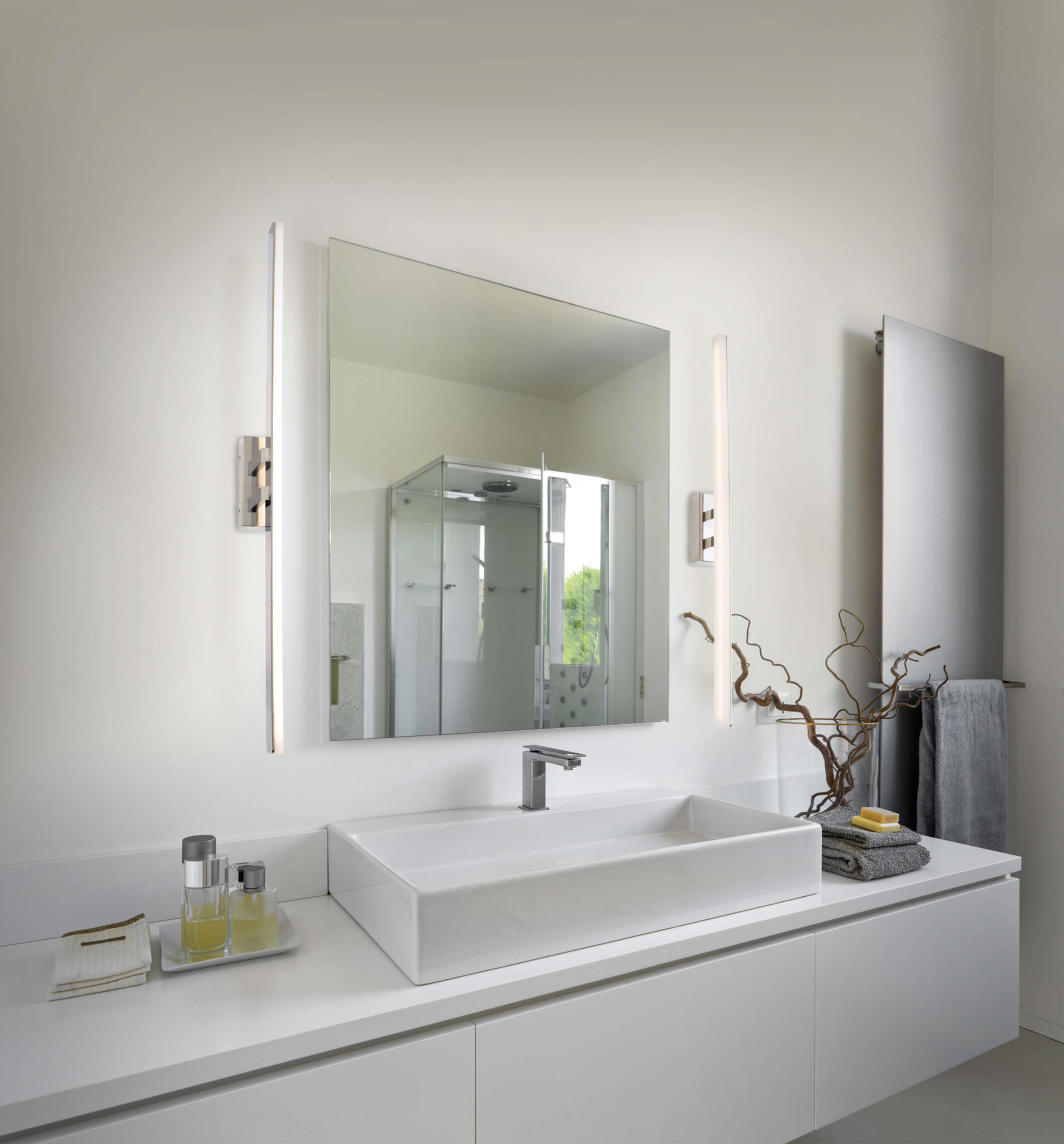 Ein modernes Badezimmer mit großem Spiegel, Waschbecken und minimalistischem Design.