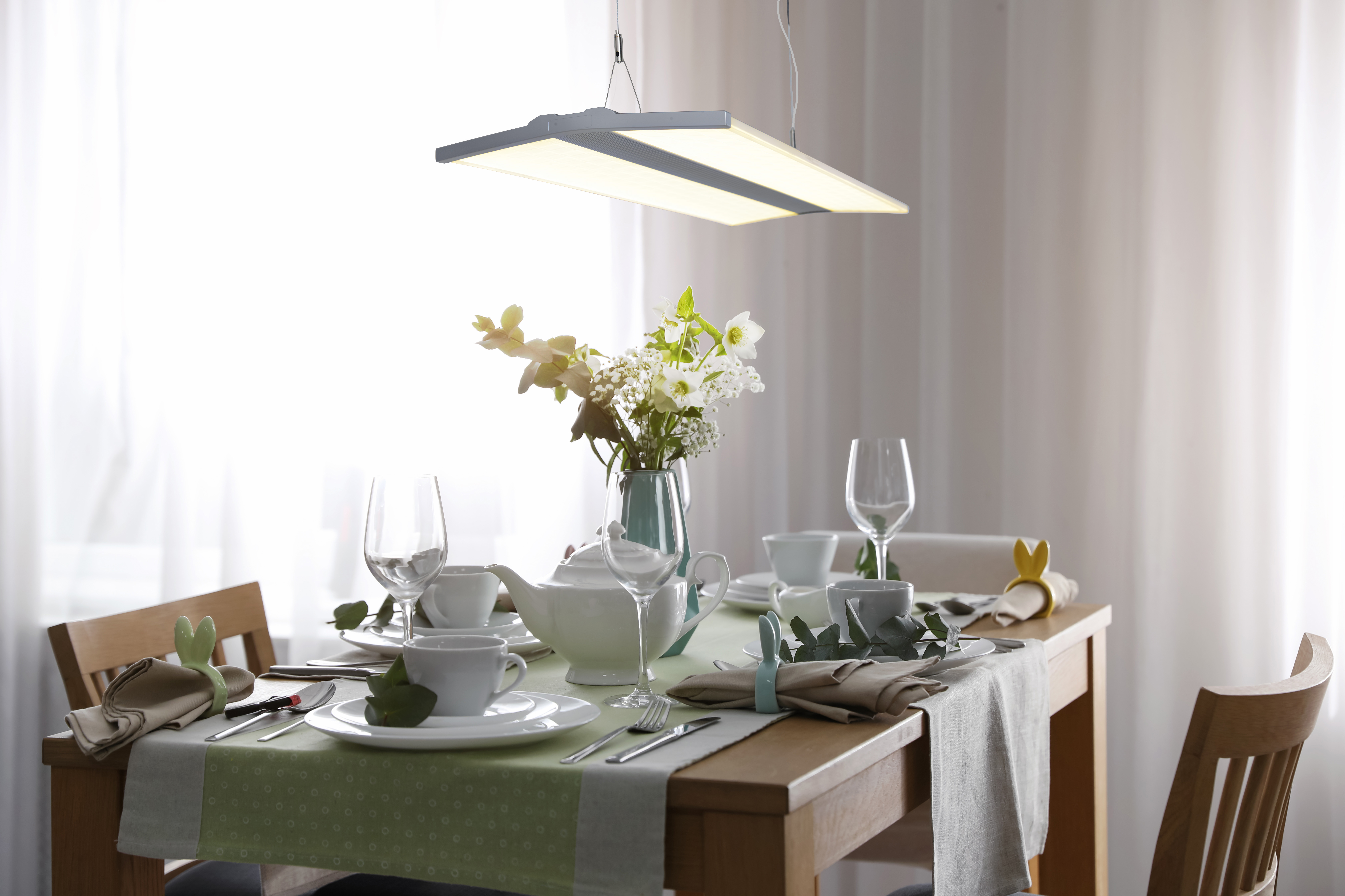 Ein gedeckter Tisch mit Blumen, Gläsern und Tellern.