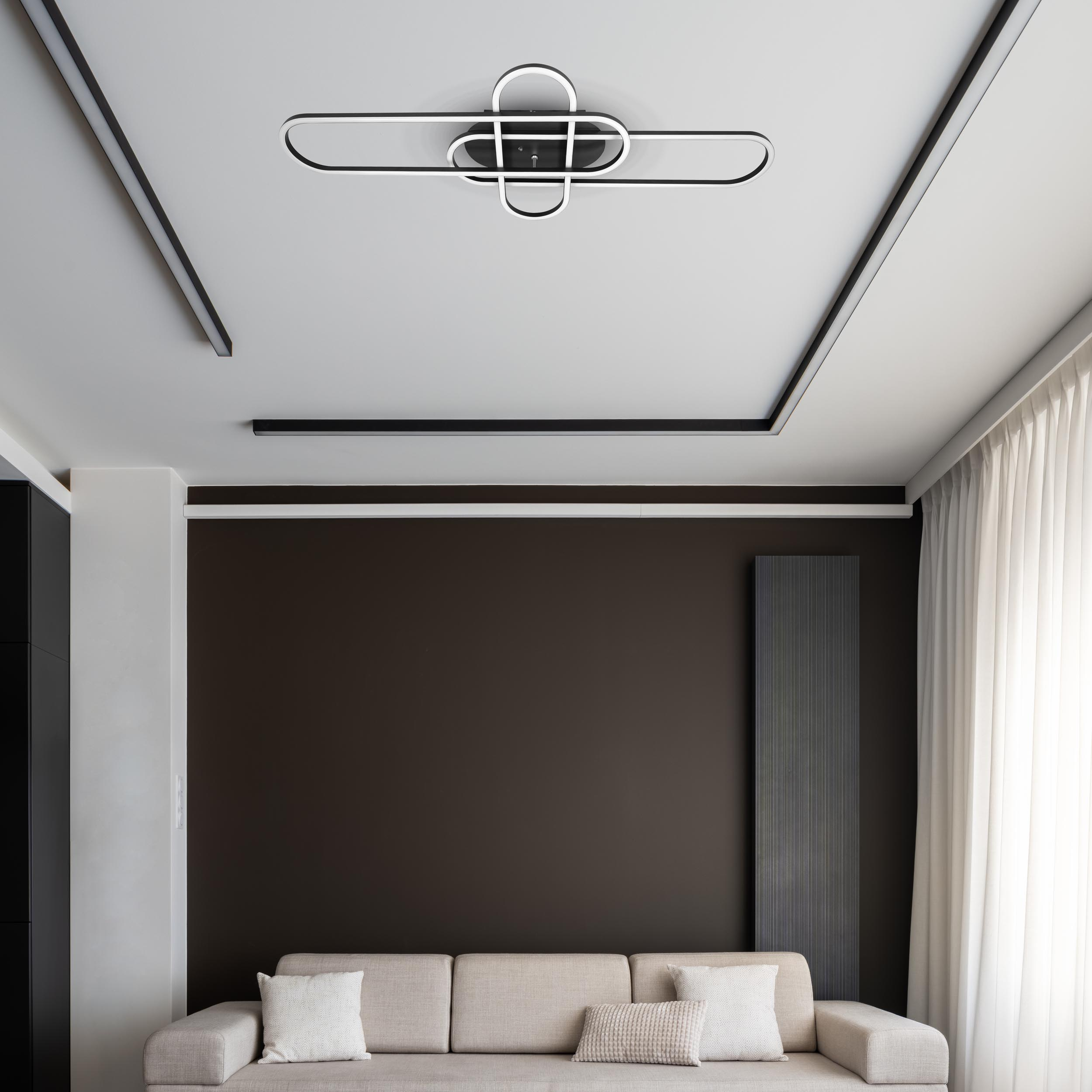 Moderne Deckenleuchte mit Schwarz-Weiß-Design. Eine weiße Decke und eine dunkelbraune Wand.