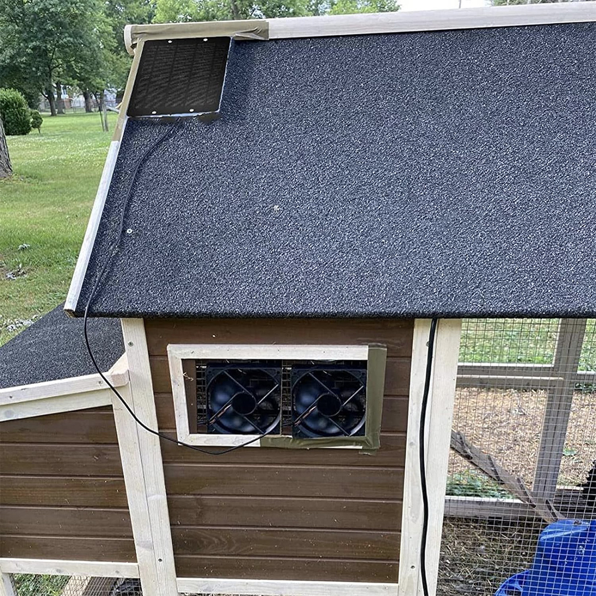 Ein Hühnerstall-Dach mit Solarpanel und zwei Ventilatoren zur Belüftung.